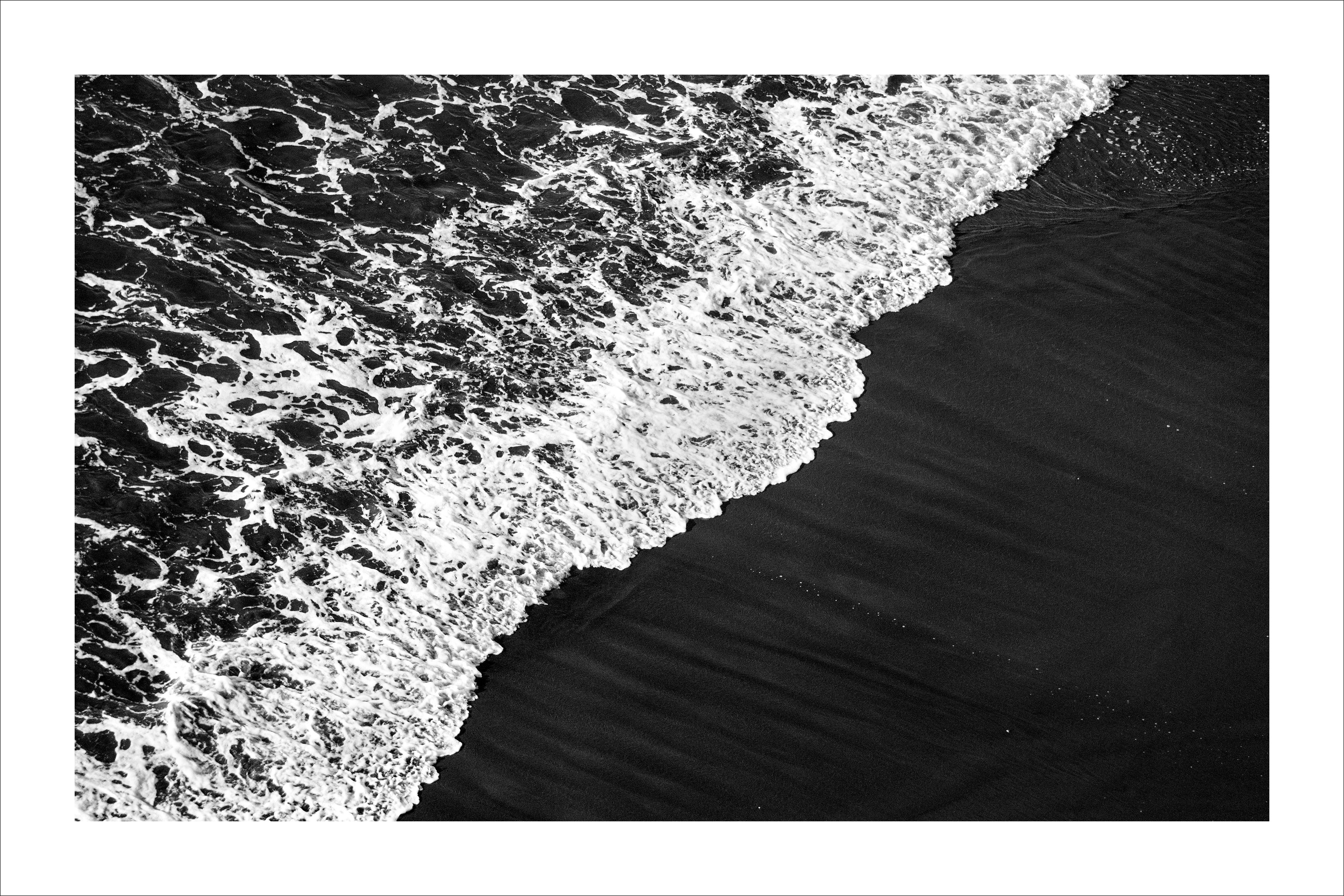 Black and White Photograph Kind of Cyan - Shore de sable noir profond, paysage marin noir et blanc, vague éclatante qui attire sur la côte