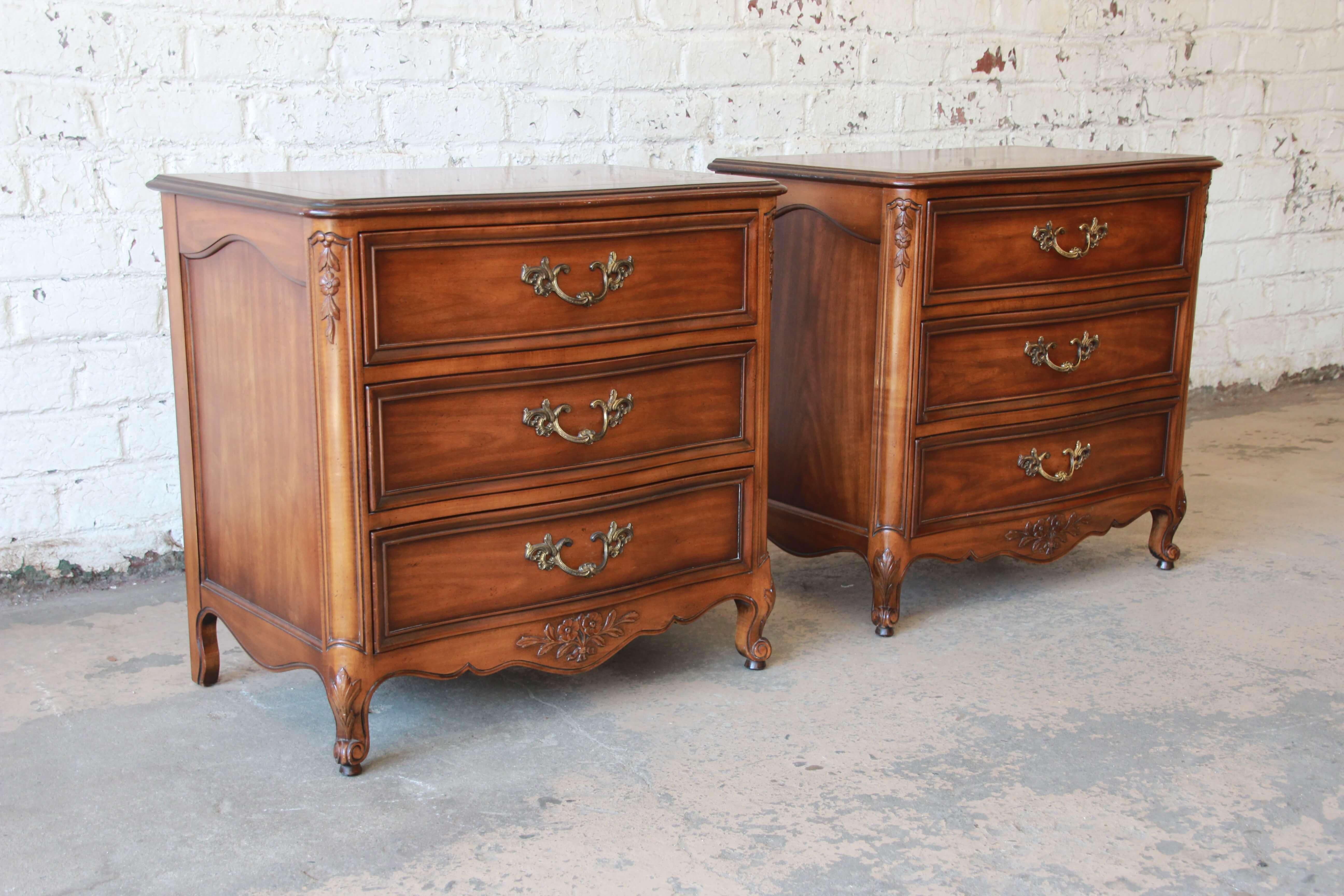 Offering a very nice pair of French Provincial three-drawer nightstands. The chest has beautiful French carved details with brass pulls and floral details. The chest has three drawers that offer ample room for storage as nightstands or small dresser