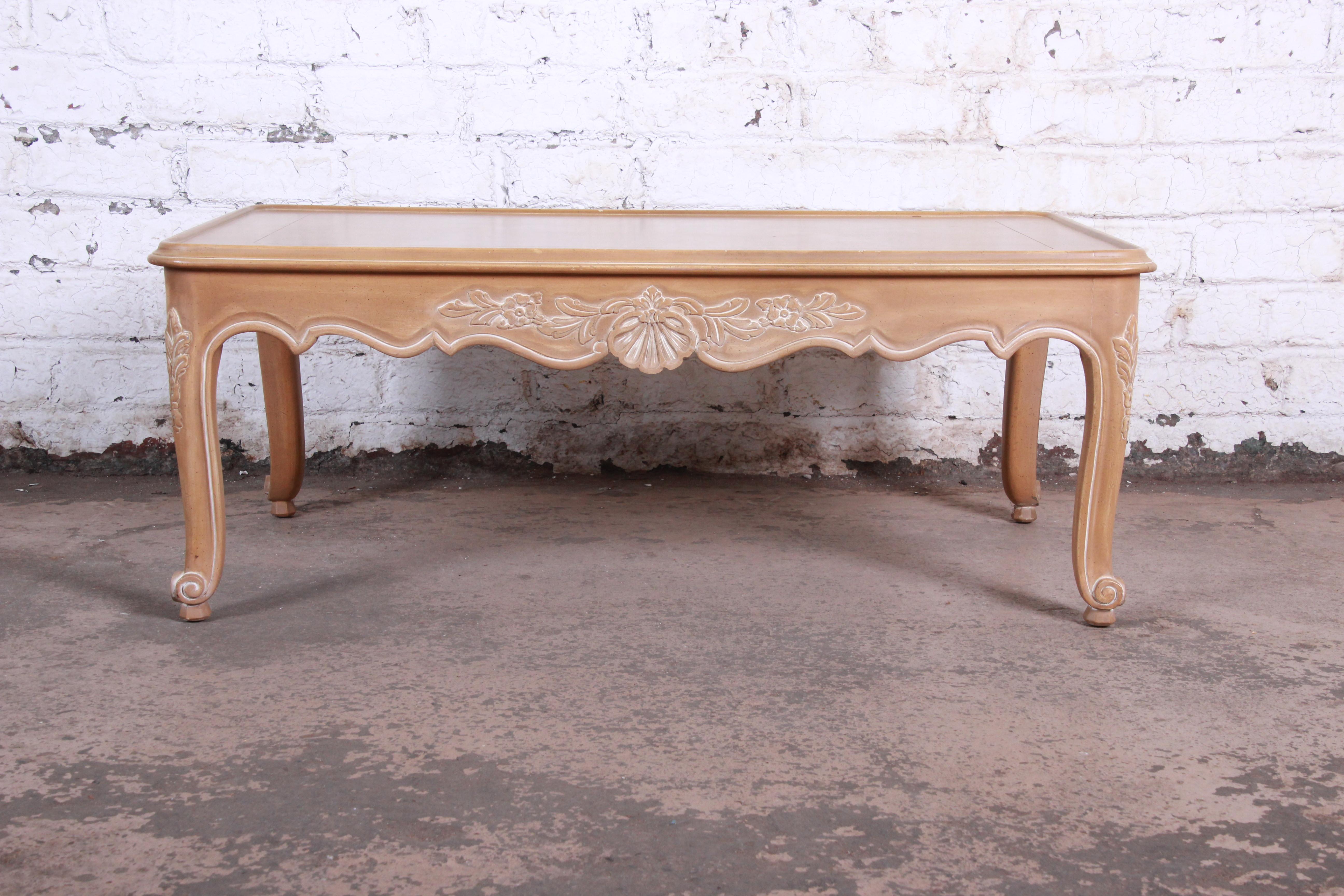A gorgeous carved French Provincial Louis XV style coffee table by Kindel Furniture of Grand Rapids. The table features beautiful carved wood details, with a scalloped apron and cabriole legs. Made with the highest quality craftsmanship, as expected