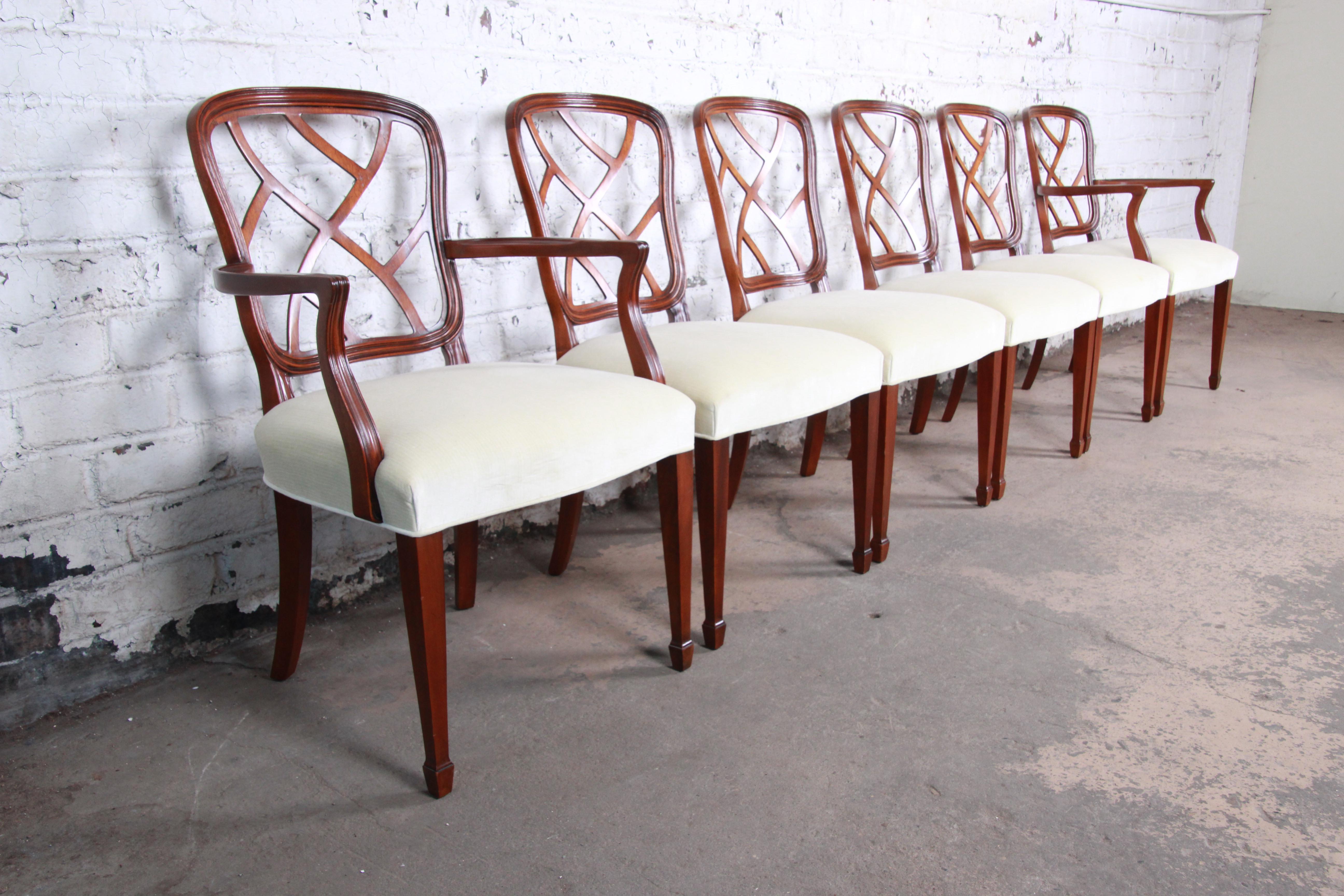 An exceptional set of carved mahogany formal dining chairs by Kindel Furniture of Grand Rapids. The set includes two captain armchairs and four side chairs. The chairs feature solid mahogany frames with unique carved seat backs. The ivory velvet