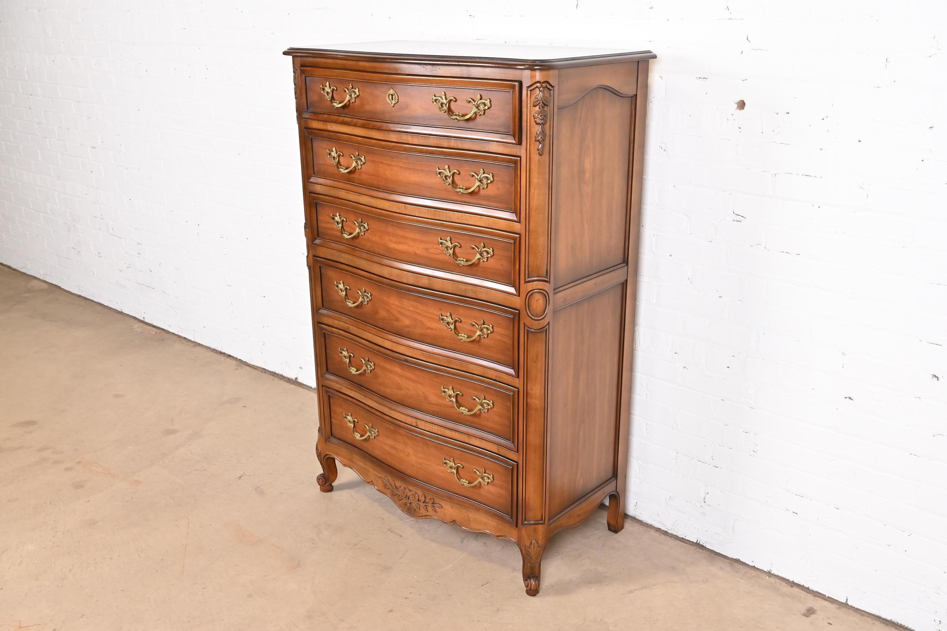 A gorgeous French Provincial Louis XV style six-drawer highboy dresser

By Kindel Furniture

USA, Circa 1980s

Carved solid cherry wood, with original brass hardware. Top drawer locks, and key is included.

Measures: 36