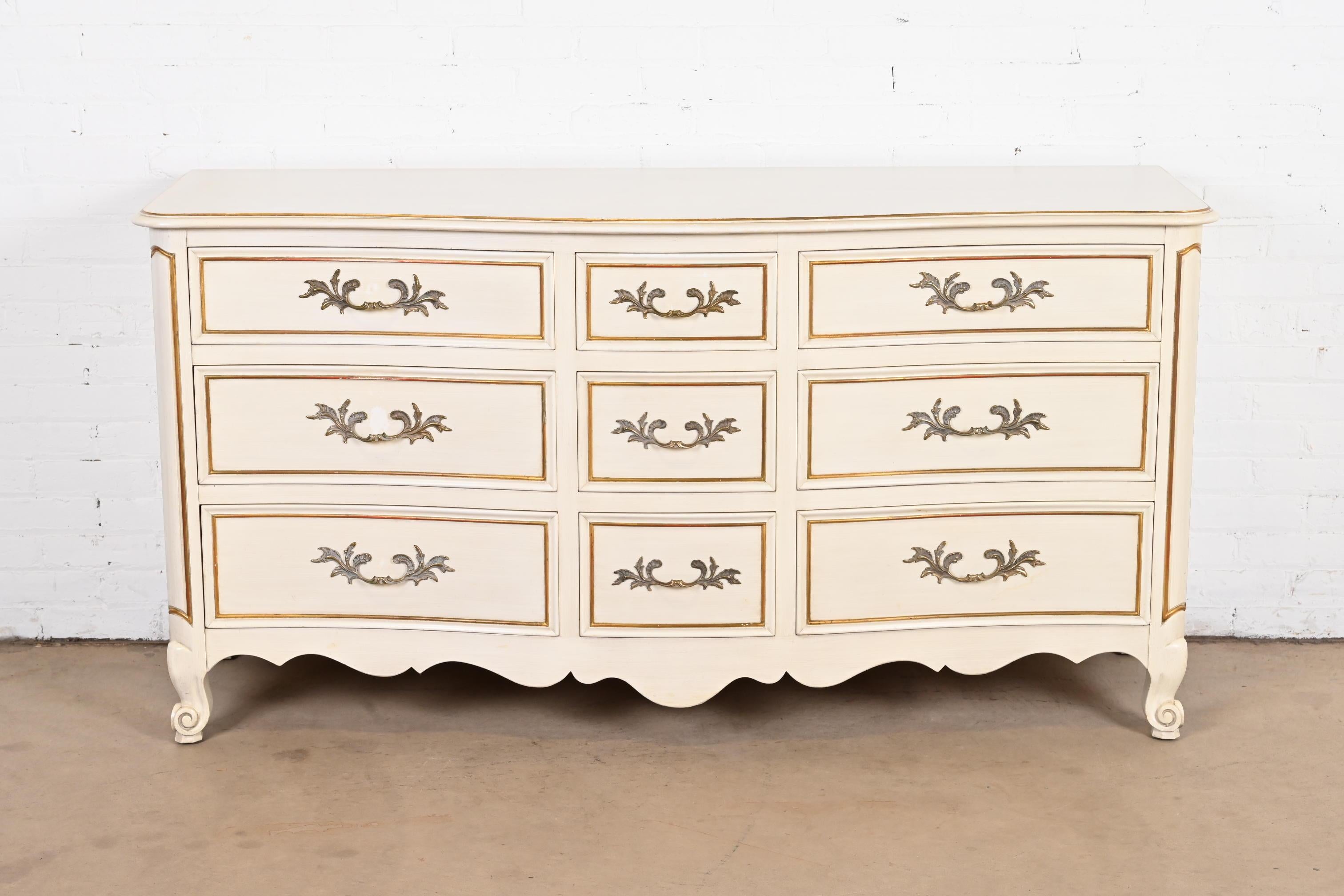 A gorgeous French Provincial Louis XV style nine-drawer dresser or chest of drawers

By Kindel Furniture

USA, circa 1960s

Cream painted carved solid cherry wood, with gold gilt painted trim, and original brass hardware.

Measures: 66
