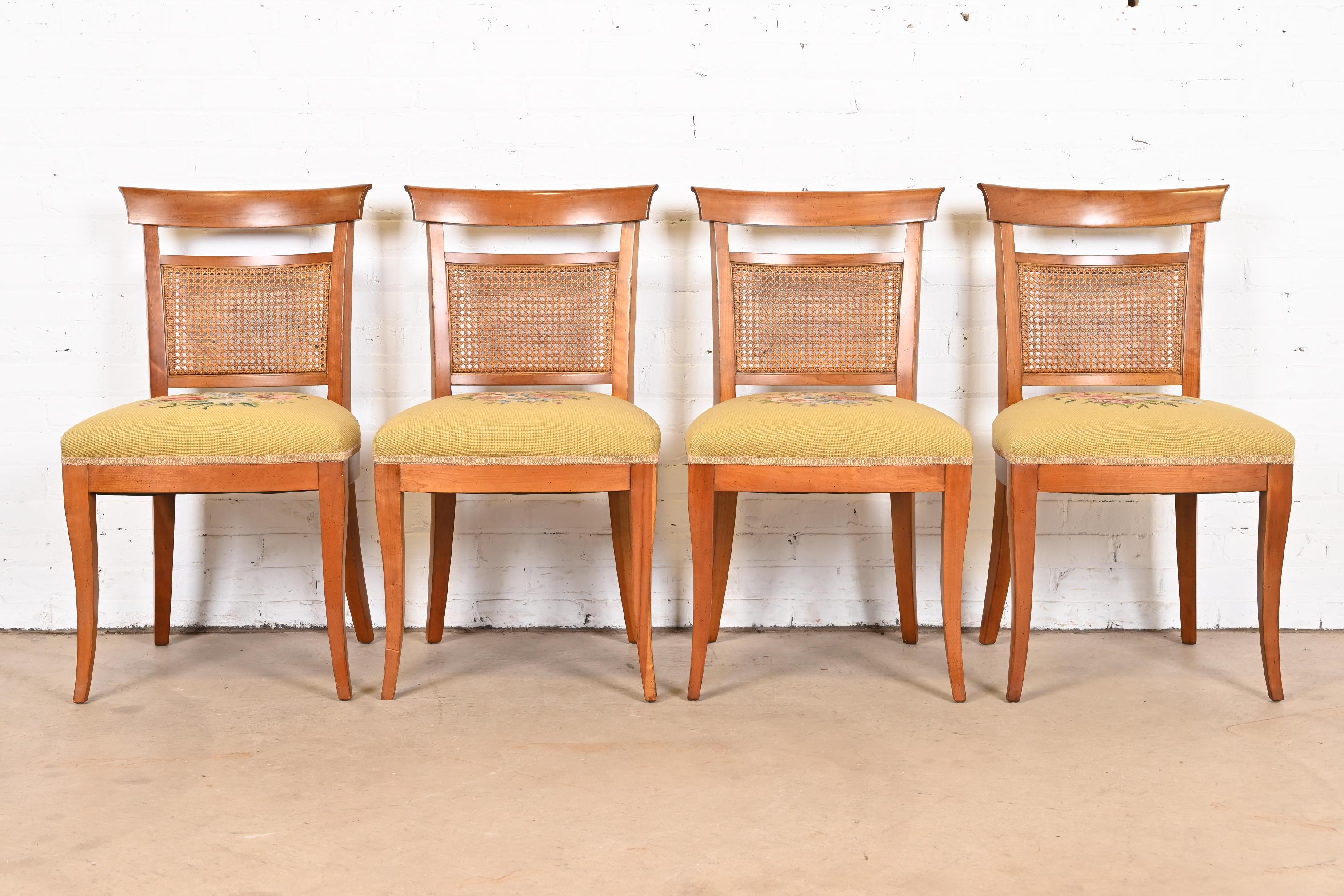 A gorgeous set of four French Regency style dining chairs

By Kindel Furniture

USA, Circa 1960s

Carved cherry wood frames, with caned seat backs, and yellow needlepoint upholstered seats.

Measures: 19.5