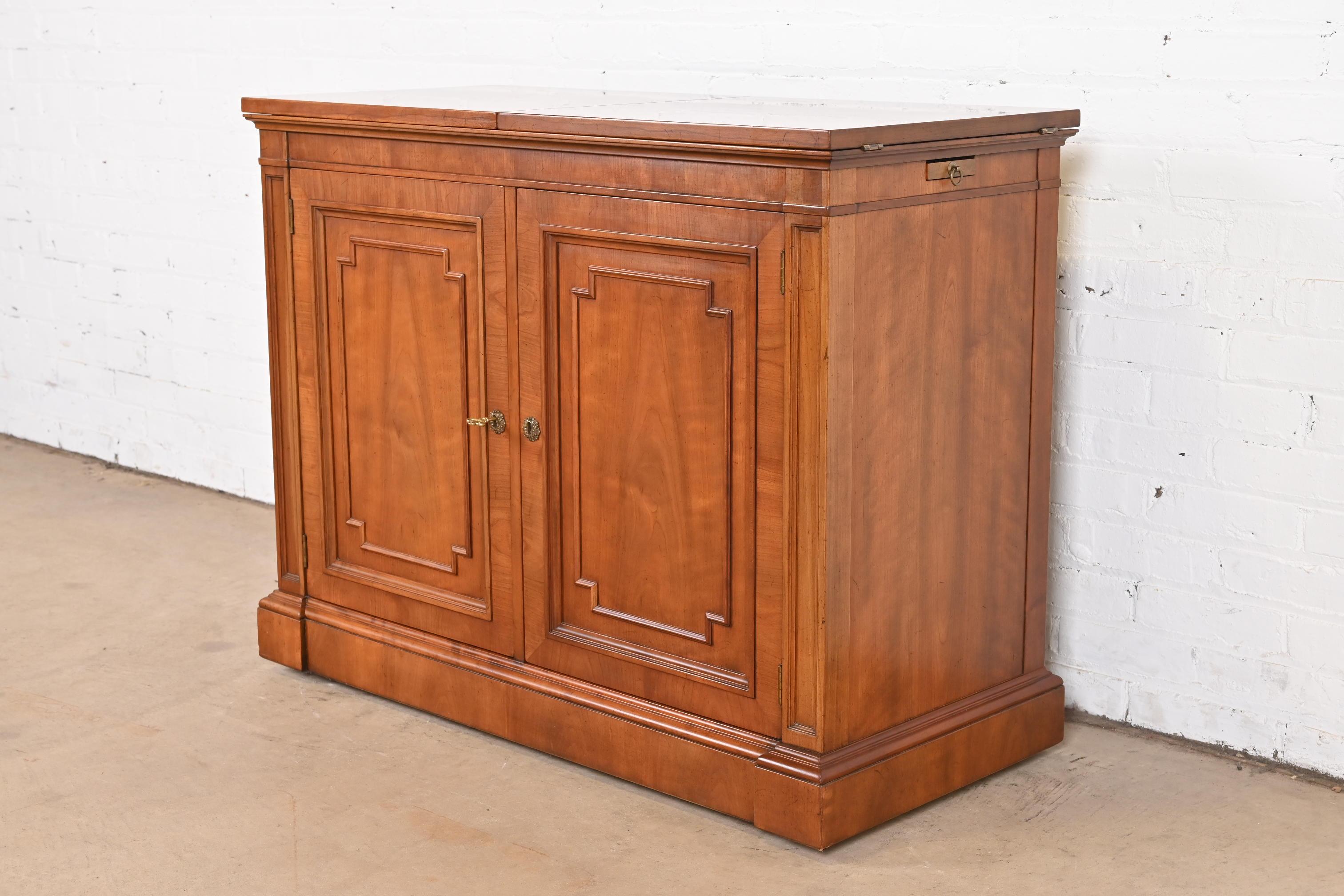 A gorgeous French Regency Louis XVI style flip-top rolling buffet server or bar cabinet

By Kindel Furniture

USA, Circa 1960s

Carved cherry wood, with burl wood under flip top, and original brass hardware. Cabinet locks, and key is