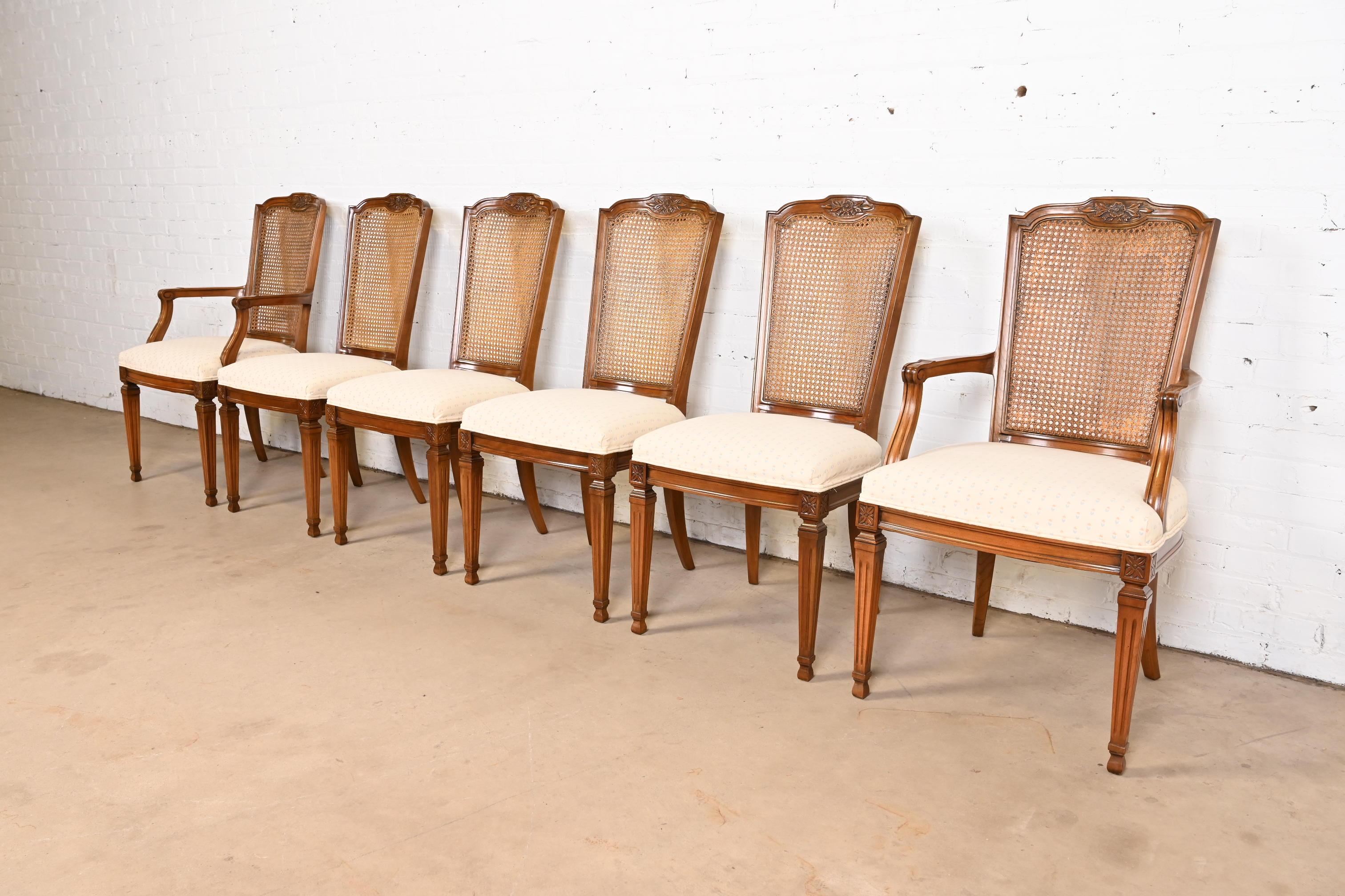 A gorgeous set of six French Regency Louis XVI style dining chairs

By Kindel Furniture

USA, Circa 1960s

Carved solid cherry wood frames, with caned backs and upholstered seats.

Measures: 
Side chairs - 19