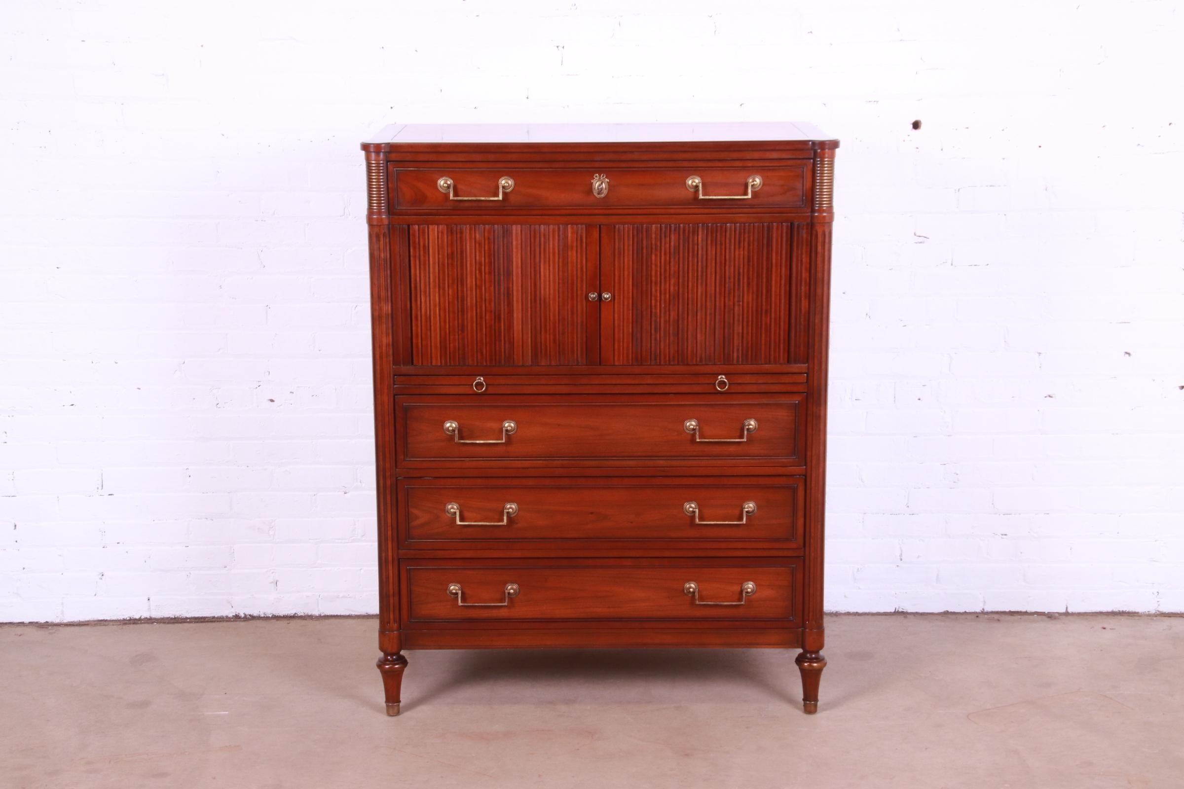 A gorgeous French Regency Louis XVI style gentleman's chest or highboy dresser

By Kindel Furniture

USA, Circa 1980s

Carved cherry wood, with tambour doors and original brass hardware.

Measures: 39.5