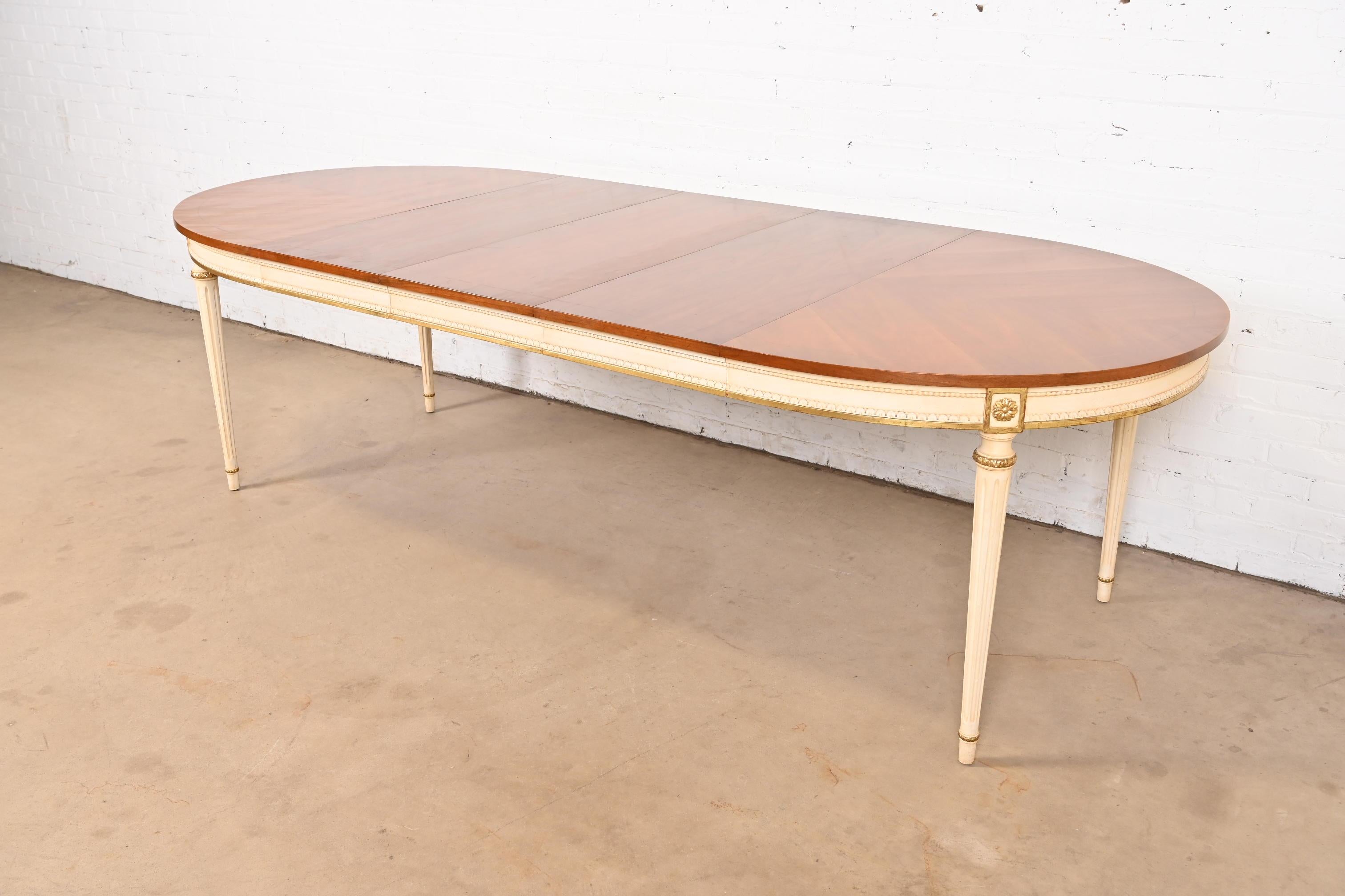 An exceptional French Regency Louis XVI style extension dining table

By Kindel Furniture

USA, Circa 1960s

Gorgeous book-matched cherry wood top, with cream lacquered and gold gilt apron and legs.

Measures: 52