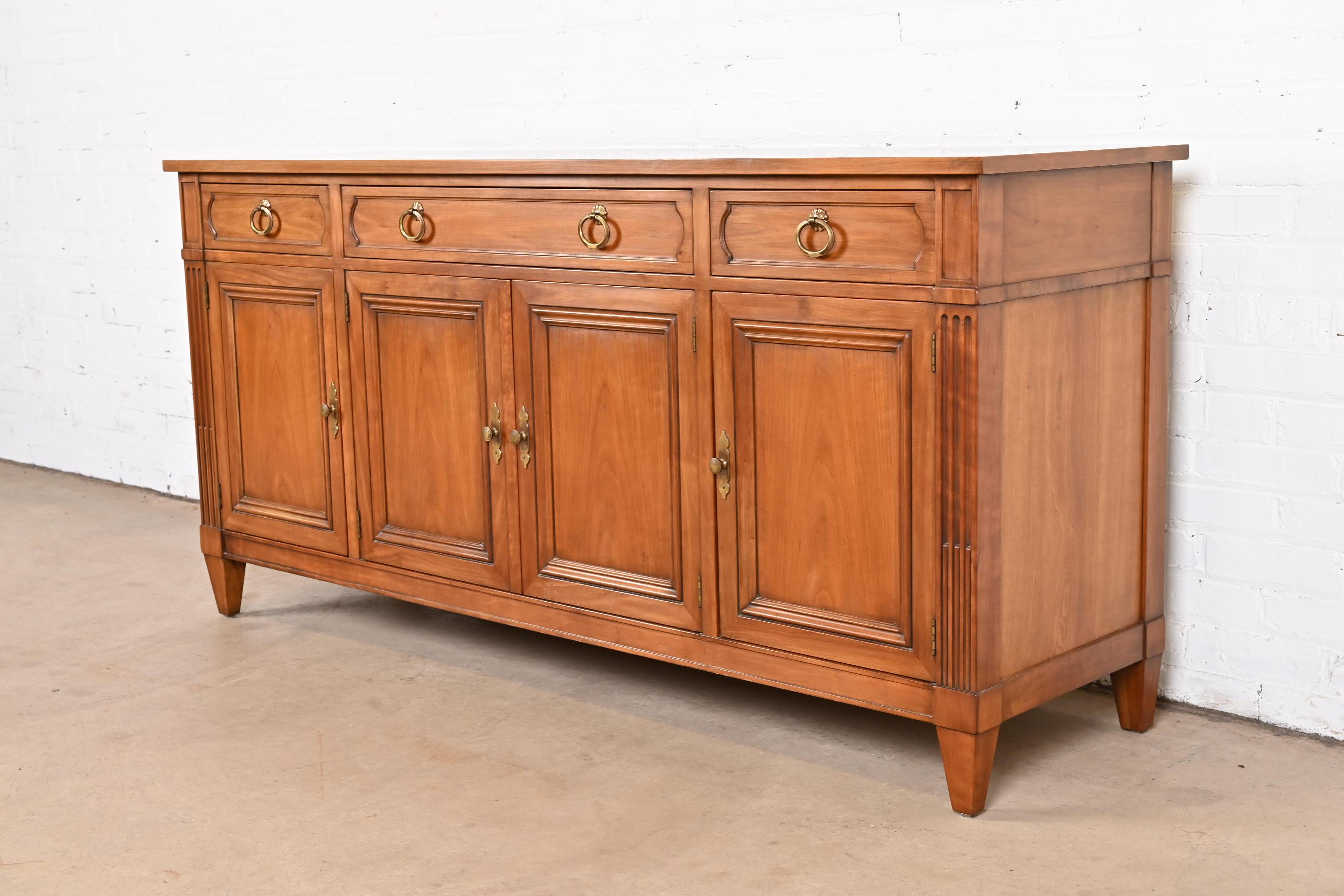 A gorgeous midcentury French Regency Louis XVI style sideboard, credenza, or bar cabinet

By Kindel Furniture

USA, Circa 1960s

Carved cherry wood, with original brass hardware.

Measures: 66
