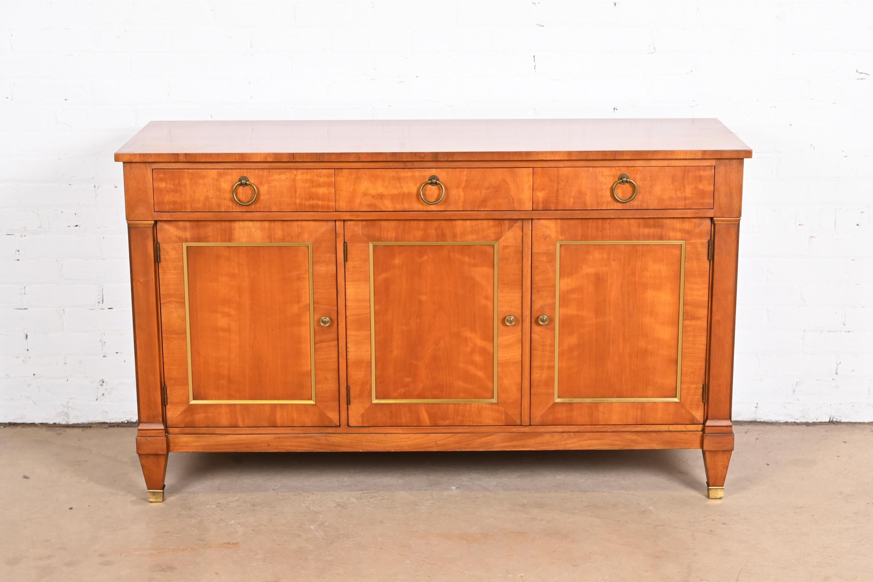 A gorgeous mid-century French Regency Louis XVI style sideboard, credenza, or bar cabinet

By Kindel Furniture

USA, Circa 1960s

Solid cherry wood, with original brass trim and hardware.

Measures: 58