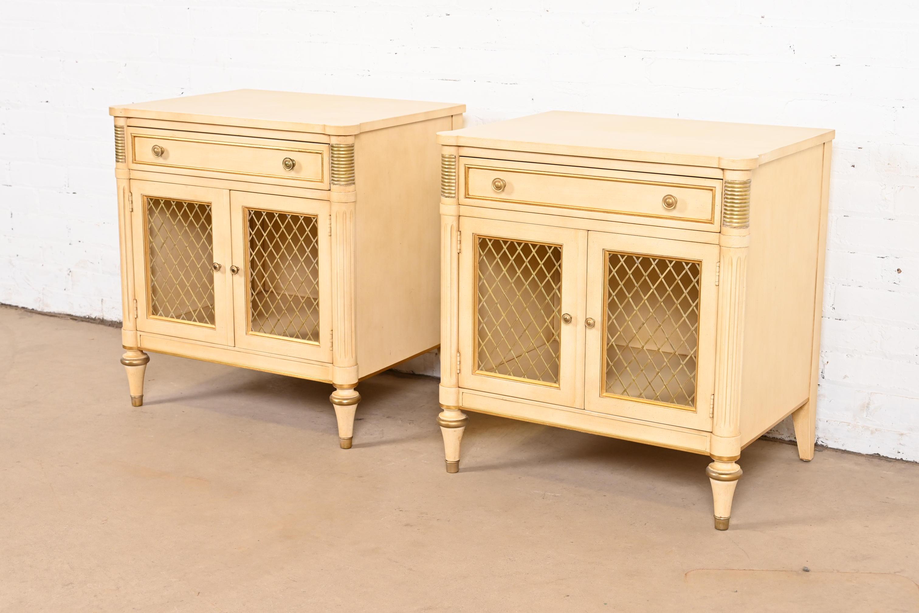 A gorgeous pair of mid-century French Regency Louis XVI style nightstands or end tables

By Kindel Furniture

USA, Circa 1960s

Carved solid cherry wood in original cream lacquer, with gold gilt and mounted brass details, and original brass