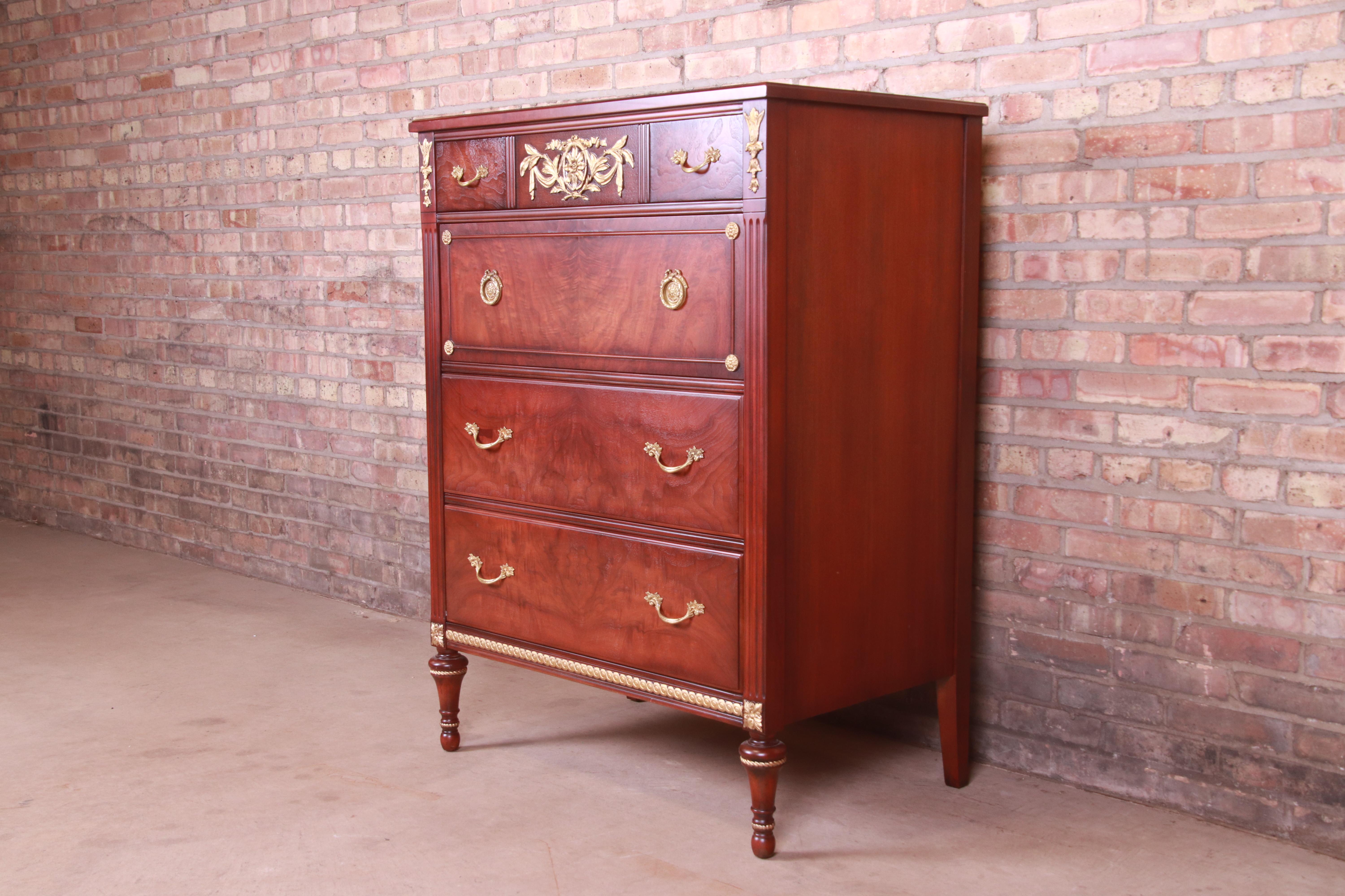 An exceptional French Regency Louis XVI style chest of drawers or highboy dresser

By Kindel Furniture

USA, Circa 1980s

Gorgeous figured walnut, with carved gold gilt details and original brass hardware.

Measures: 35