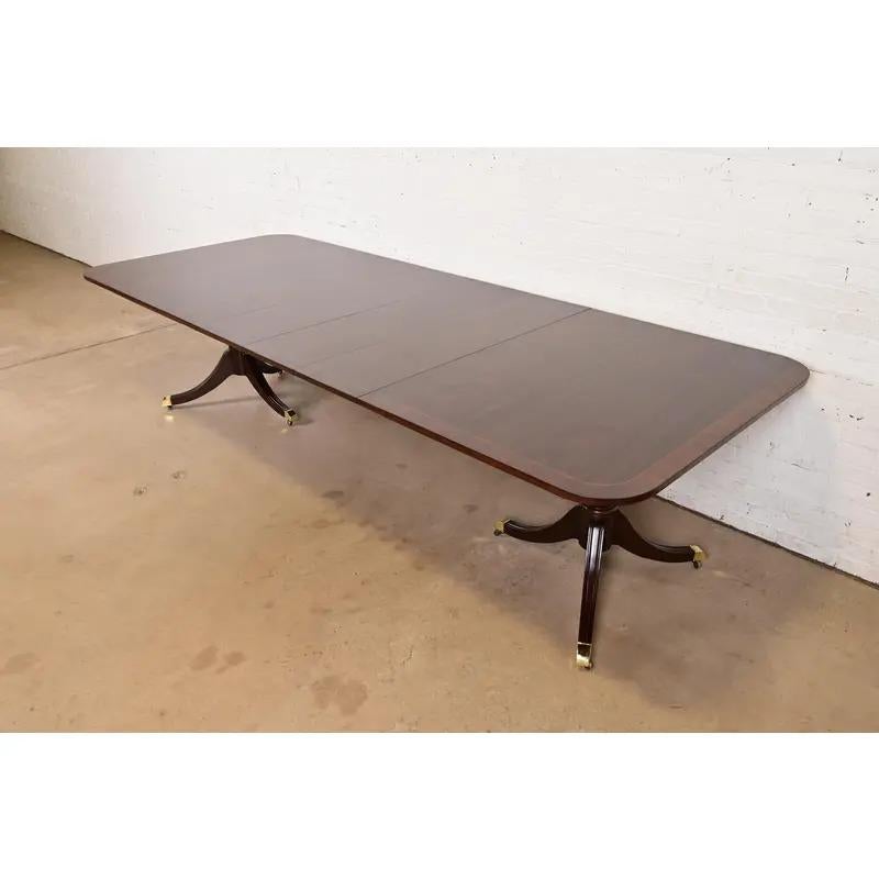 Exceptionnelle table à manger à rallonge à double piédestal de style Géorgien ou Régence.

Par Kindel Furniture

USA, Circa 1980

Magnifique plateau en acajou bagué assorti à un livre, avec des piédestaux en acajou massif sculpté, et des pieds