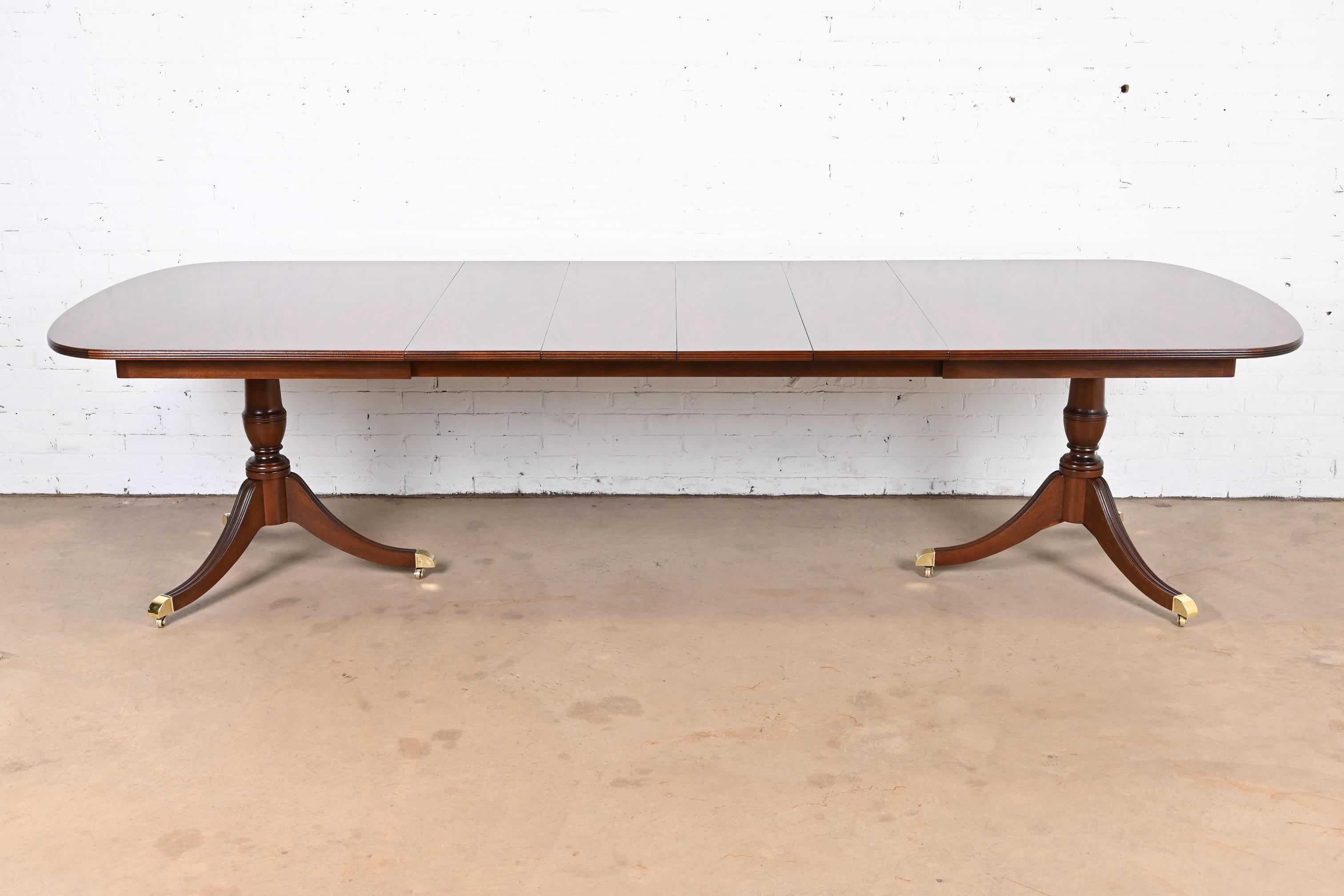 An exceptional Georgian or Regency style double pedestal extension dining table

By Kindel Furniture

USA, Circa 1980s

Gorgeous book-matched flame mahogany, carved solid mahogany pedestals, brass-capped feet, and brass casters.

Measures: