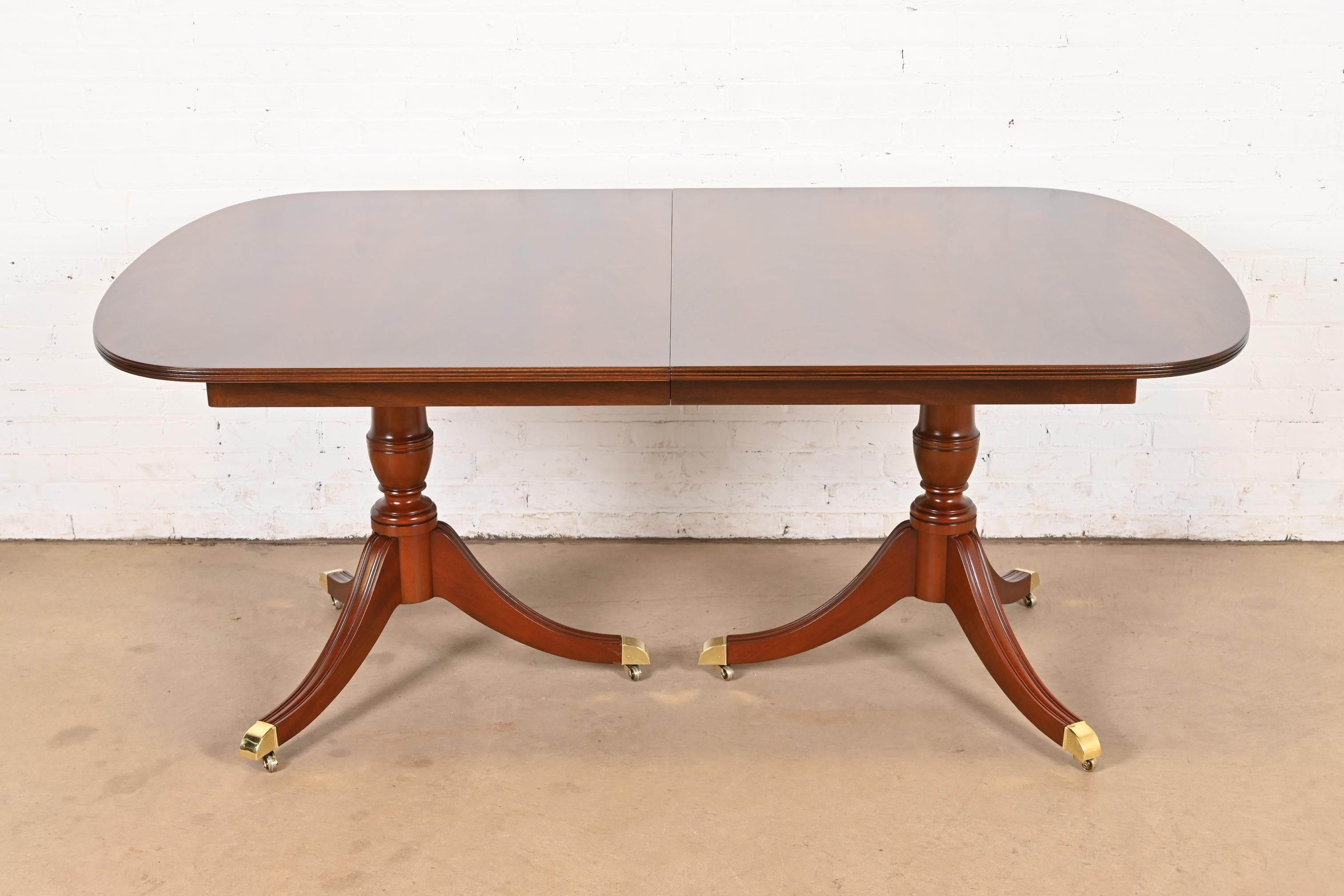 Una excepcional mesa de comedor de doble pedestal de estilo Georgiano o Regencia

Por Kindel Furniture

EE.UU., alrededor de 1980

Preciosa encimera de caoba flameada a juego con los libros, con pedestales de caoba maciza tallada, y pies con tapa de