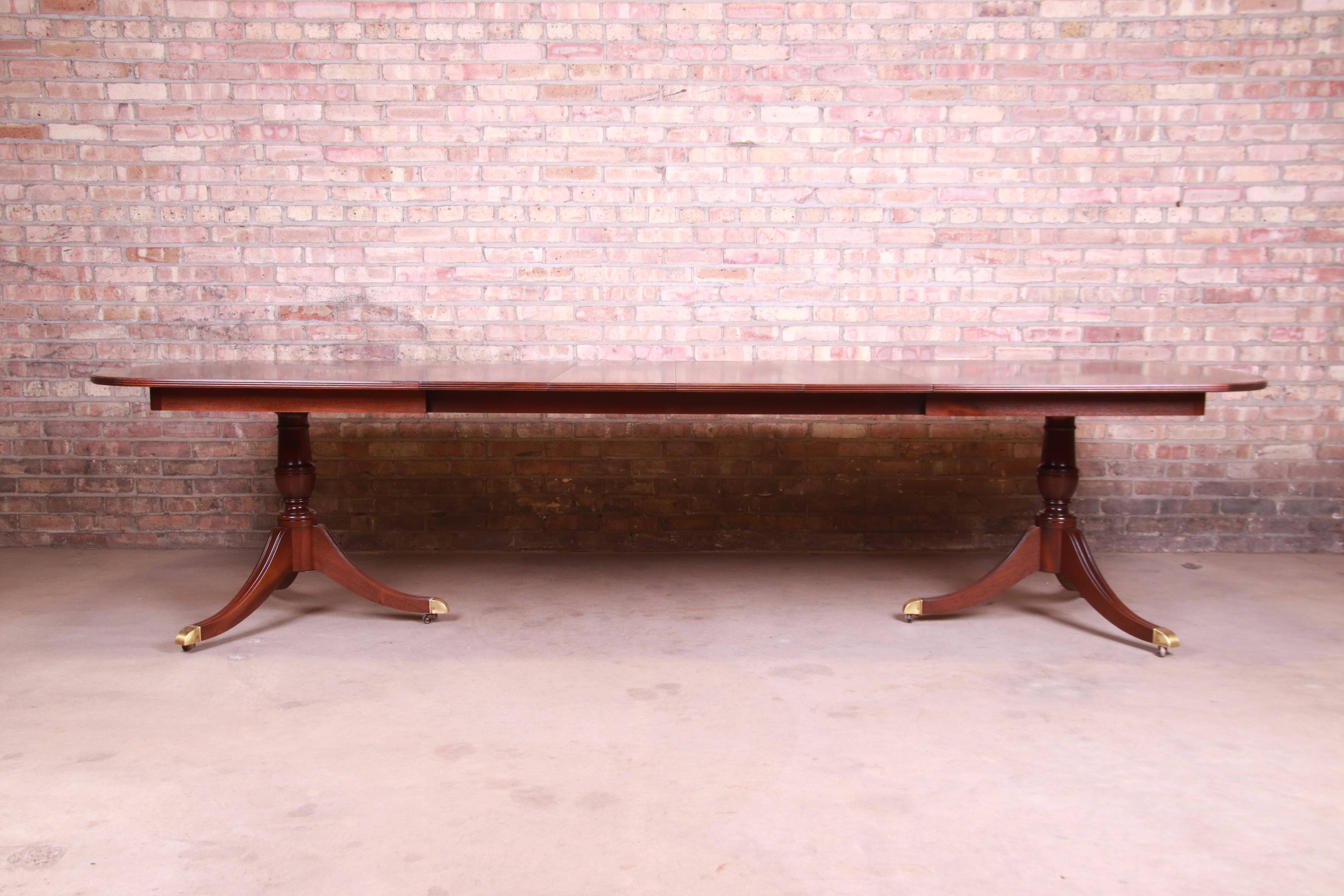 An exceptional Georgian style double pedestal extension dining table

By Kindel Furniture

USA, circa 1980s

Book-matched mahogany, with carved solid mahogany pedestals and brass-capped feet.

Measures: 72