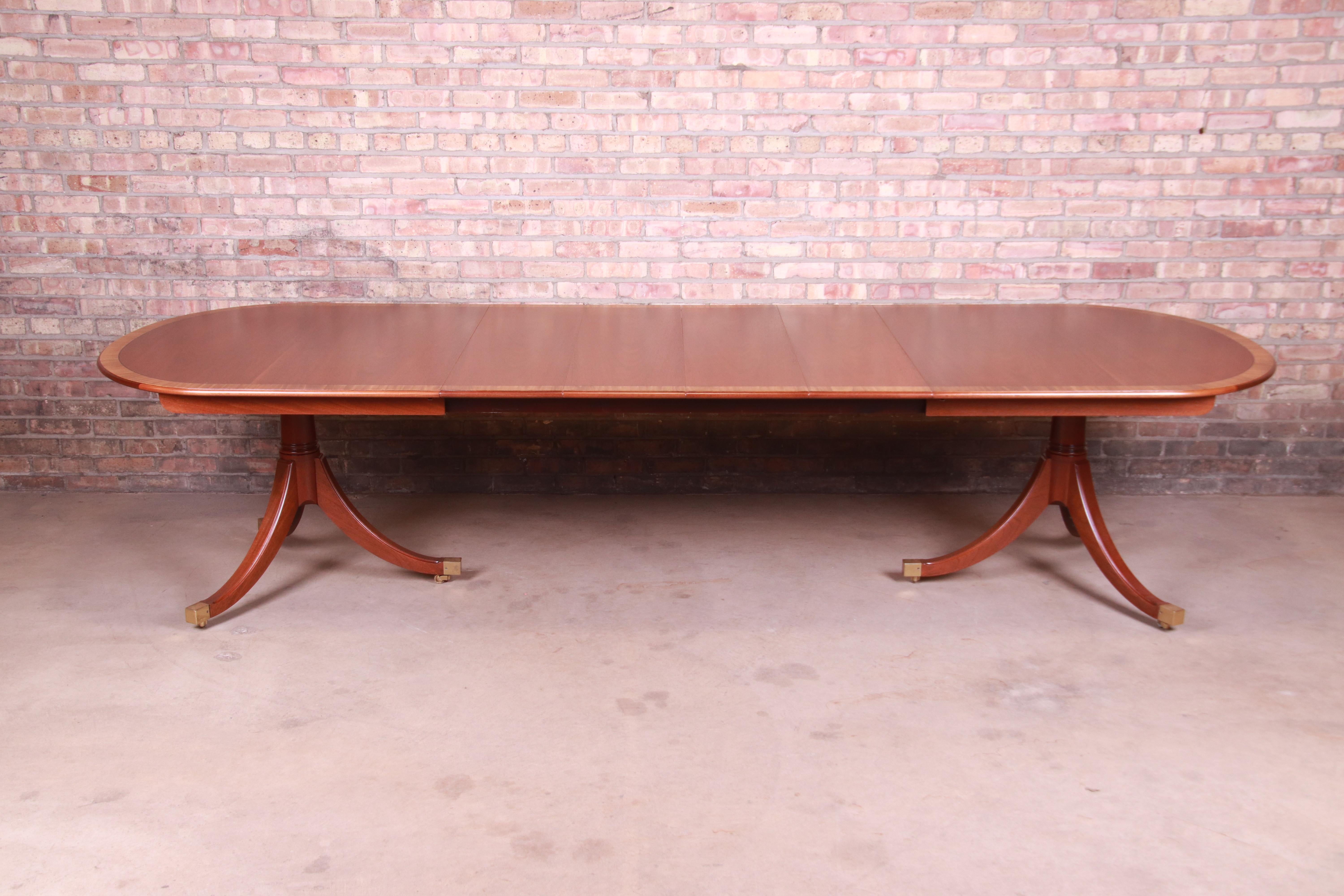 An exceptional Georgian style double pedestal extension dining table

By Kindel Furniture

USA, Circa 1980s

Book-matched mahogany with satinwood banding, carved solid mahogany pedestals, and brass-capped feet.

Measures: 78