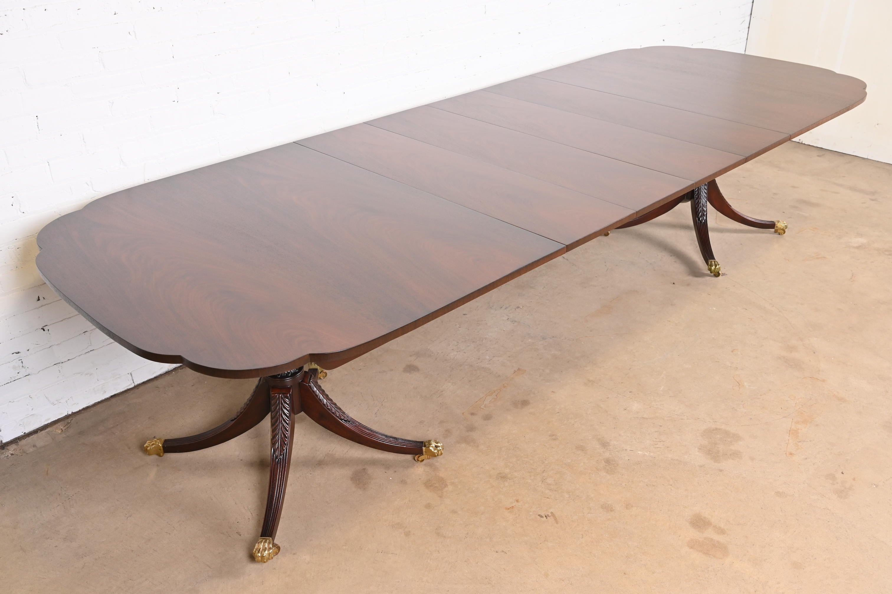 A gorgeous Georgian or Regency style double pedestal extension dining table

By Kindel Furniture

USA, circa 1980s

Solid mahogany, with scalloped corners, carved pedestals, brass paw feet, and brass casters. A unique design, with leaves that store