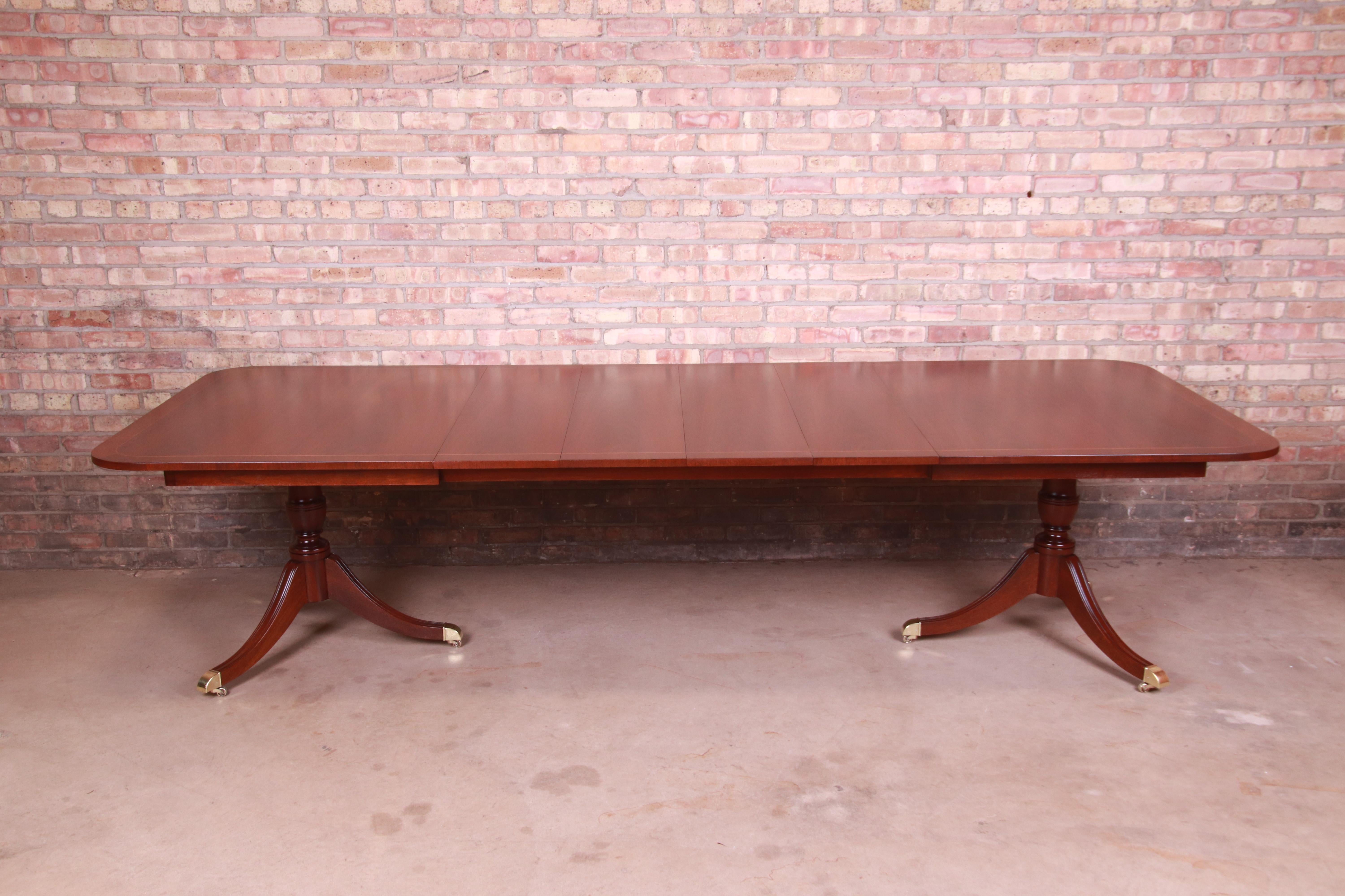 An exceptional Georgian style double pedestal extension dining table

By Kindel Furniture

USA, Circa 1980s

Book-matched mahogany with satinwood banding, carved solid mahogany pedestals, brass-capped feet, and brass casters.

Measures: 68