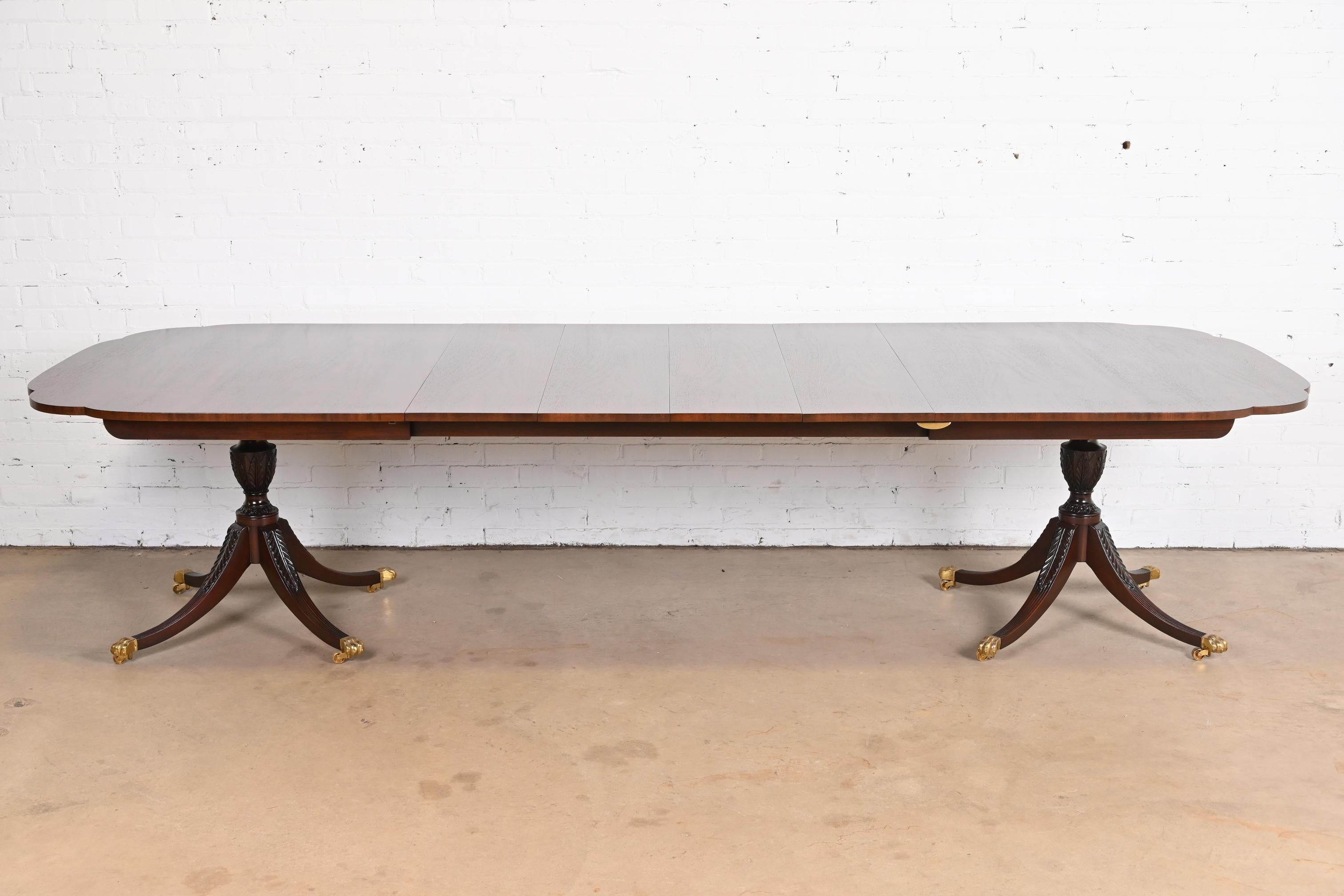 A gorgeous Georgian or Regency style double pedestal extension dining table

By Kindel Furniture

USA, circa 1980s

Solid mahogany, with scalloped corners, carved pedestals, brass paw feet, and brass casters. A unique design, with leaves that