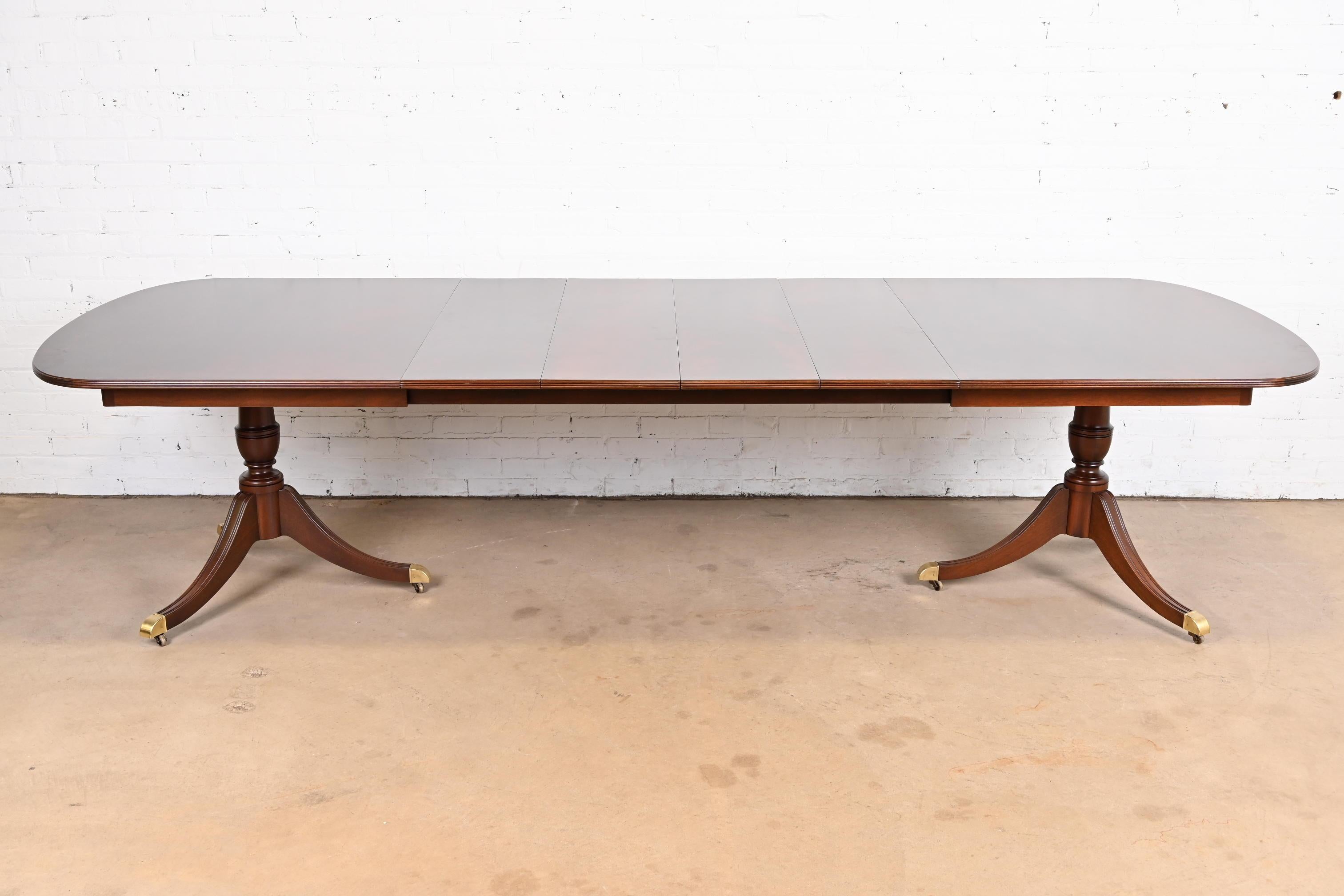 An exceptional Georgian or Regency style double pedestal extension dining table

By Kindel Furniture

USA, Circa 1980s

Gorgeous flame mahogany, with carved solid mahogany pedestals, brass-capped feet, and brass casters.

Measures: 72