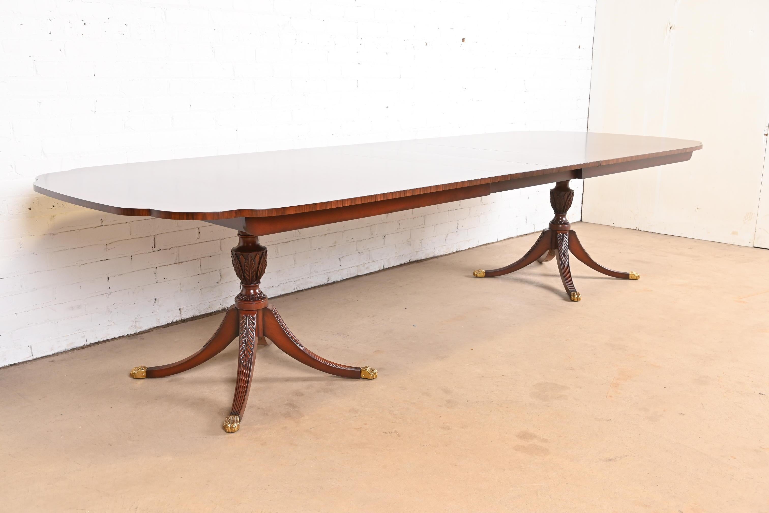 A gorgeous Georgian or Regency style double pedestal extension dining table

By Kindel Furniture

USA, Circa 1980s

Gorgeous book-matched mahogany, with satinwood inlay banding, scalloped corners, carved pedestals, and brass paw feet.

Measures: