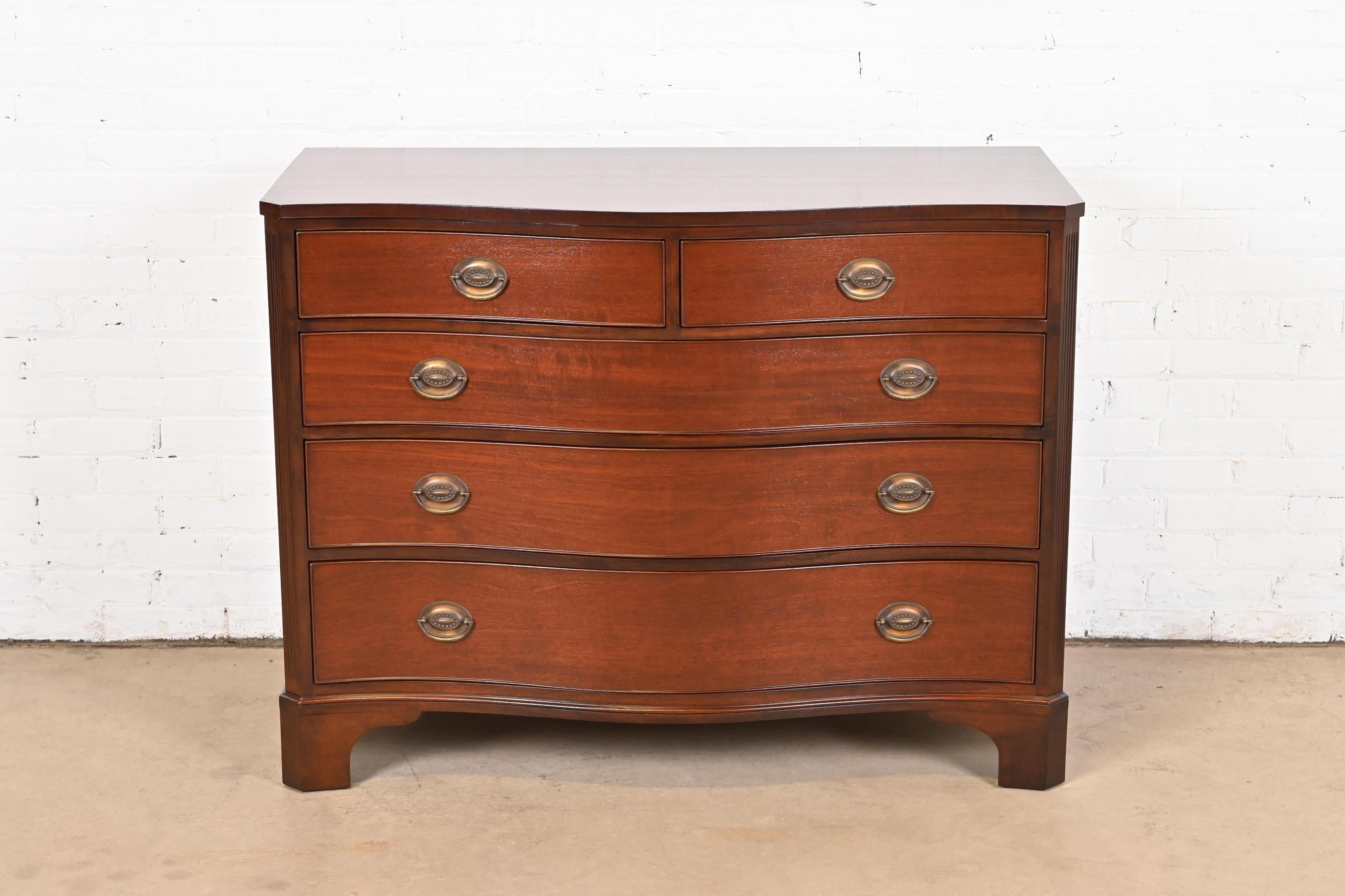 An exceptional Georgian or Chippendale style serpentine front dresser, chest of drawers, or commode

By Kindel Furniture

USA, Circa 1960s

Gorgeous carved mahogany, with original brass hardware.

Measures: 46