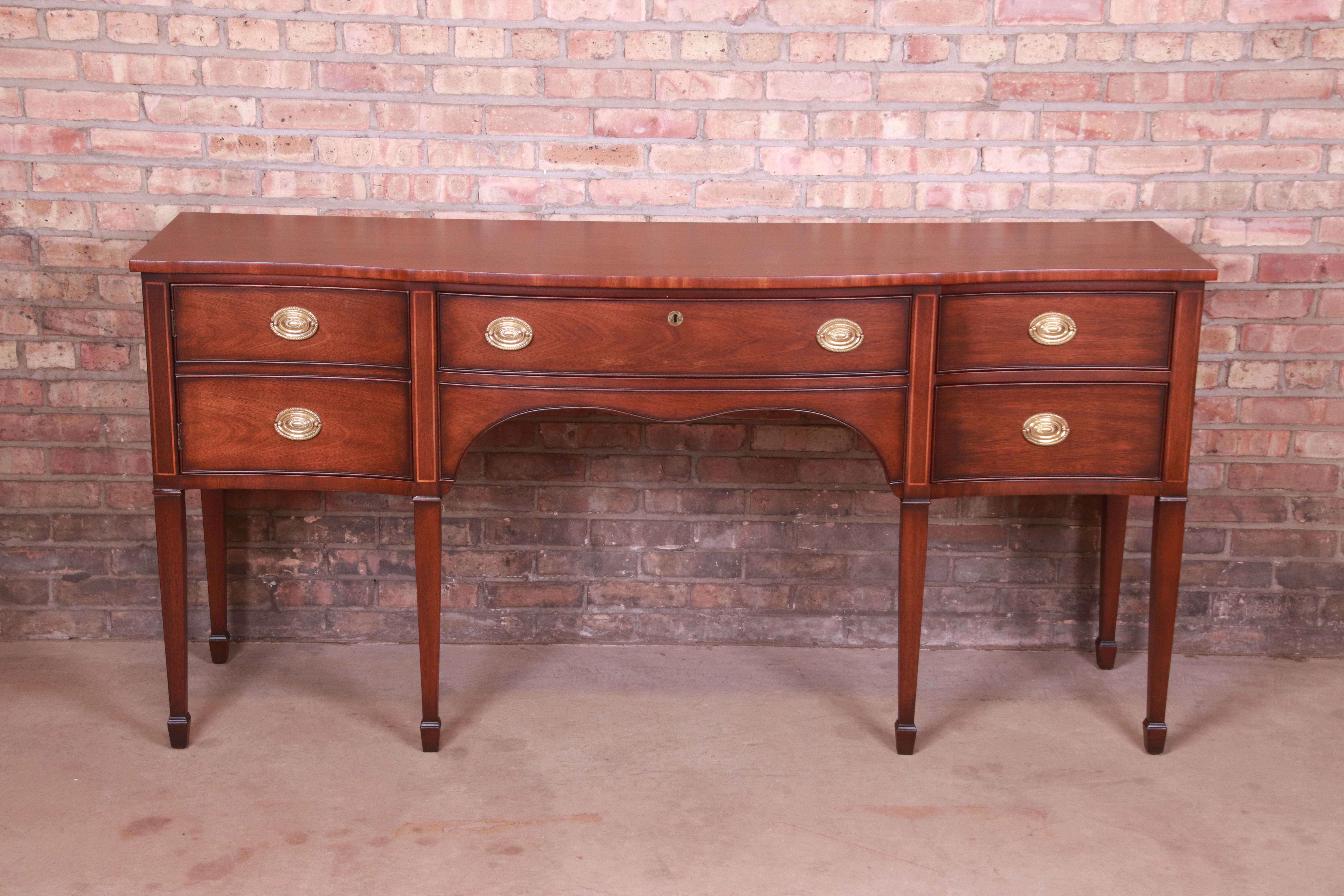 A gorgeous Hepplewhite or Federal style bow front sideboard buffet or credenza

By Kindel Furniture

USA, Circa 1980s

Mahogany, with satinwood string inlay and original brass hardware.

Measures: 72