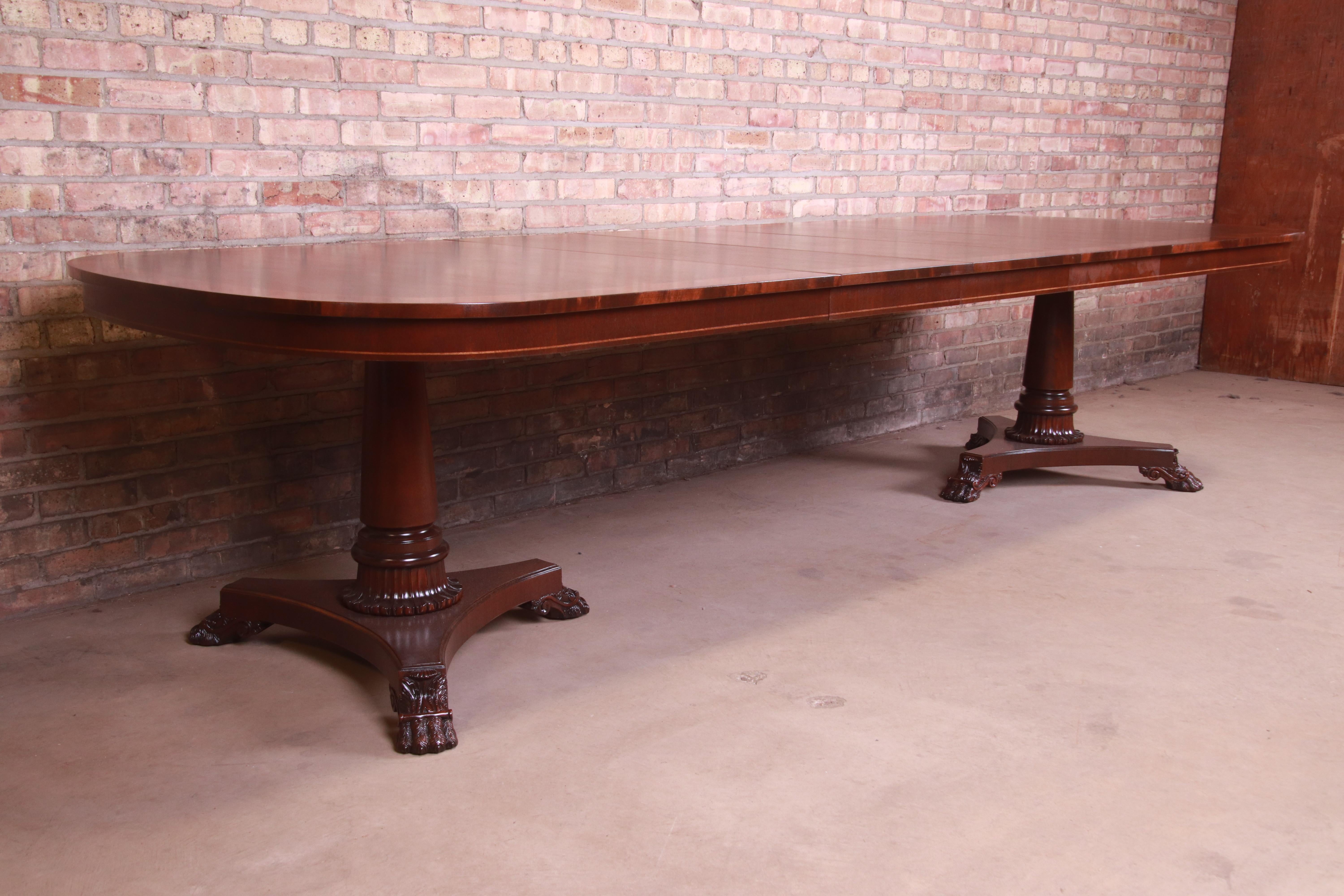 An exceptional neoclassical or Empire style double pedestal extension dining table

By Kindel Furniture

USA, 1990s

Book-matched mahogany, with flame mahogany banding and carved solid mahogany column pedestals with paw feet.

Measures: 80