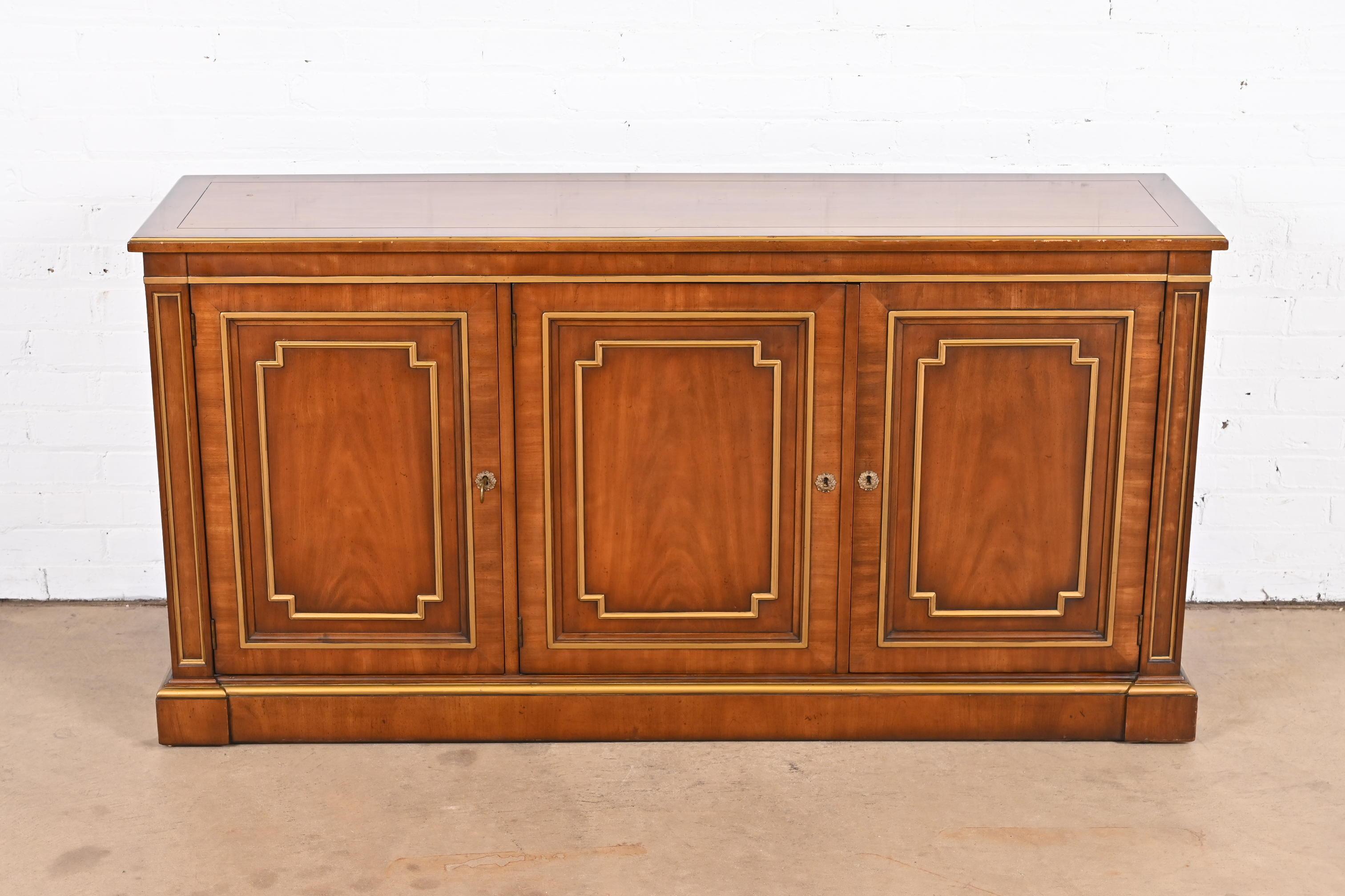An exceptional neoclassical or Regency style sideboard, credenza, or bar cabinet

By Kindel Furniture

USA, 1970s

Gorgeous book-matched cherry wood, with gold gilt details. Cabinets lock, and key is included.

Measures: 59