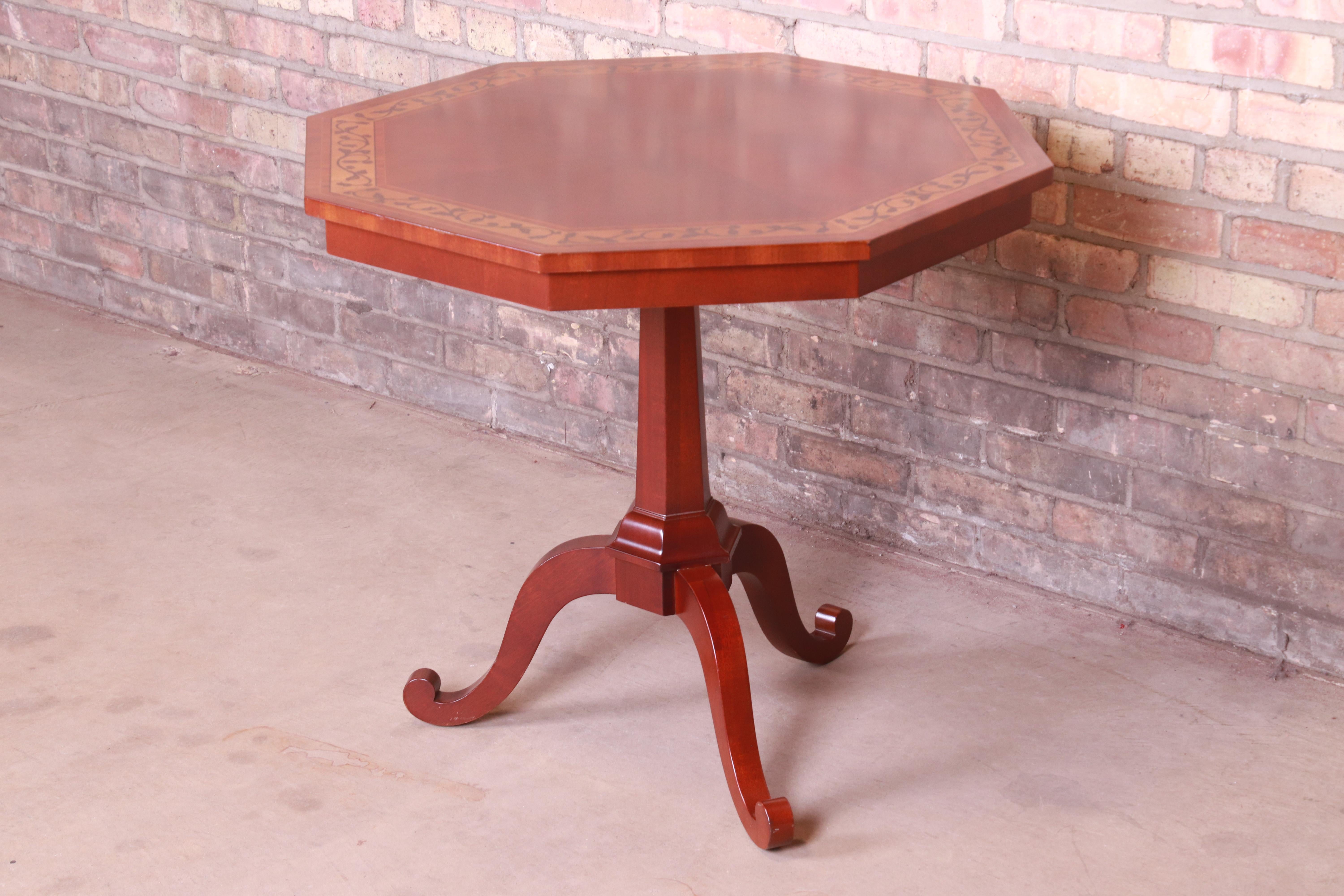 A gorgeous Regency style pedestal tea table or occasional side table

By Kindel Furniture

USA, circa 1980s

Bookmatched mahogany in starburst pattern, with inlaid satinwood banding with floral design.

Measures: 30