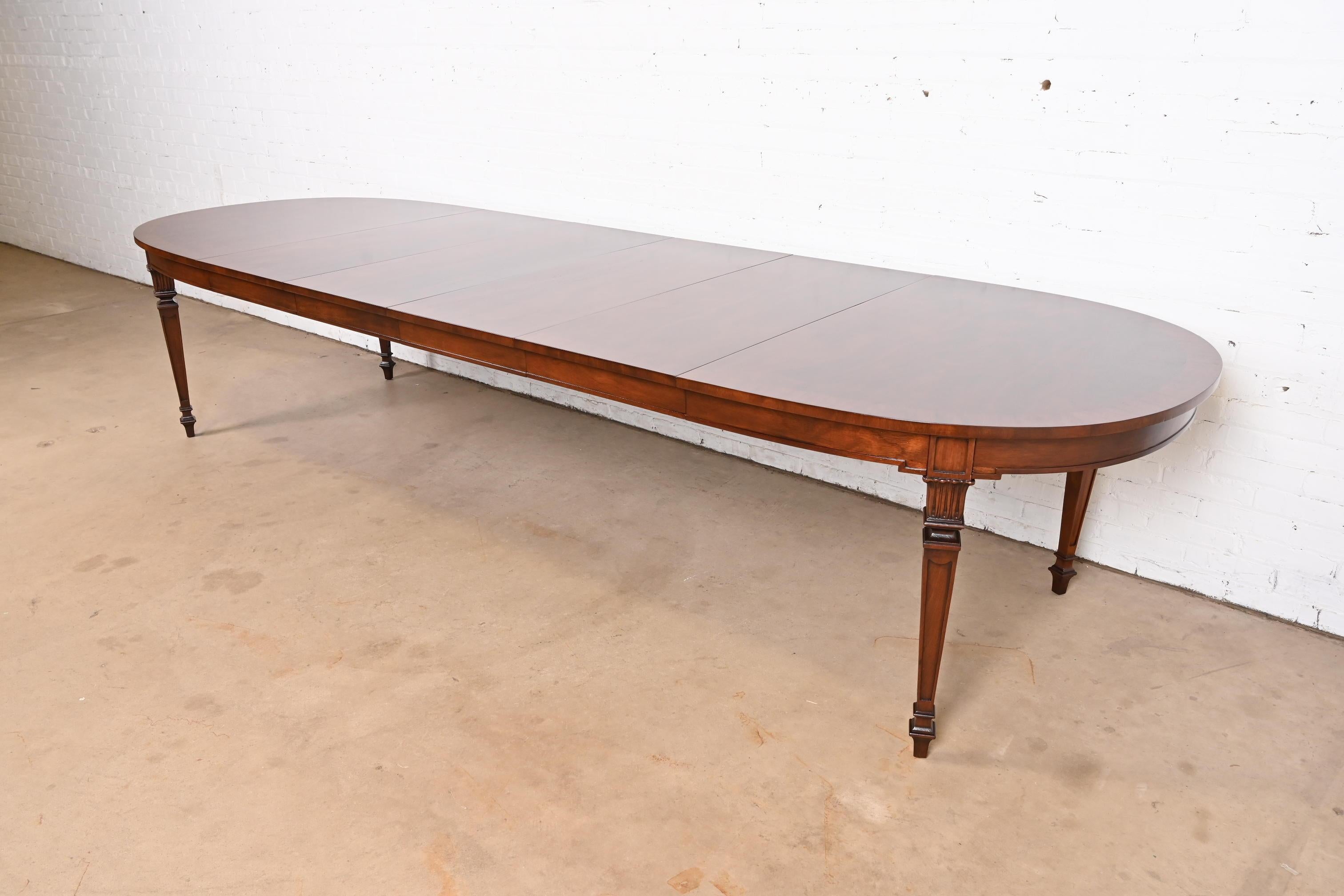 An exceptional French Regency Louis XVI style extension dining table

In the manner of Kindel Furniture

USA, Circa 1960s

Gorgeous book-matched banded burled walnut top, with carved solid walnut legs.

Measures: 66