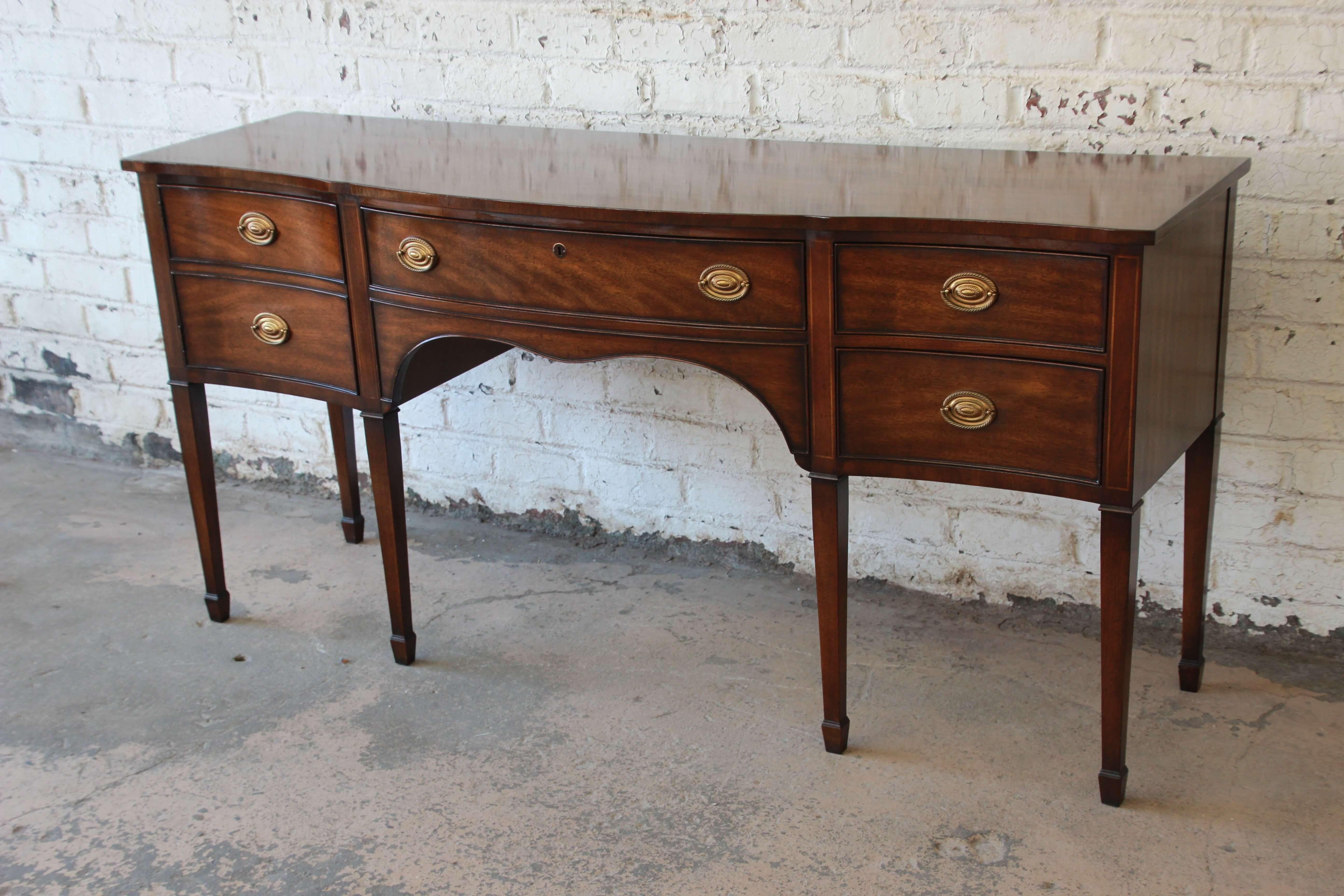 Offering a very nice traditional Kindle Furniture Windermere Hepplewhite style mahogany sideboard. The credenza sits on tall legs with spade feet and has a nice rich mahogany wood grain. The left side of the credenza has a cabinet door which opens