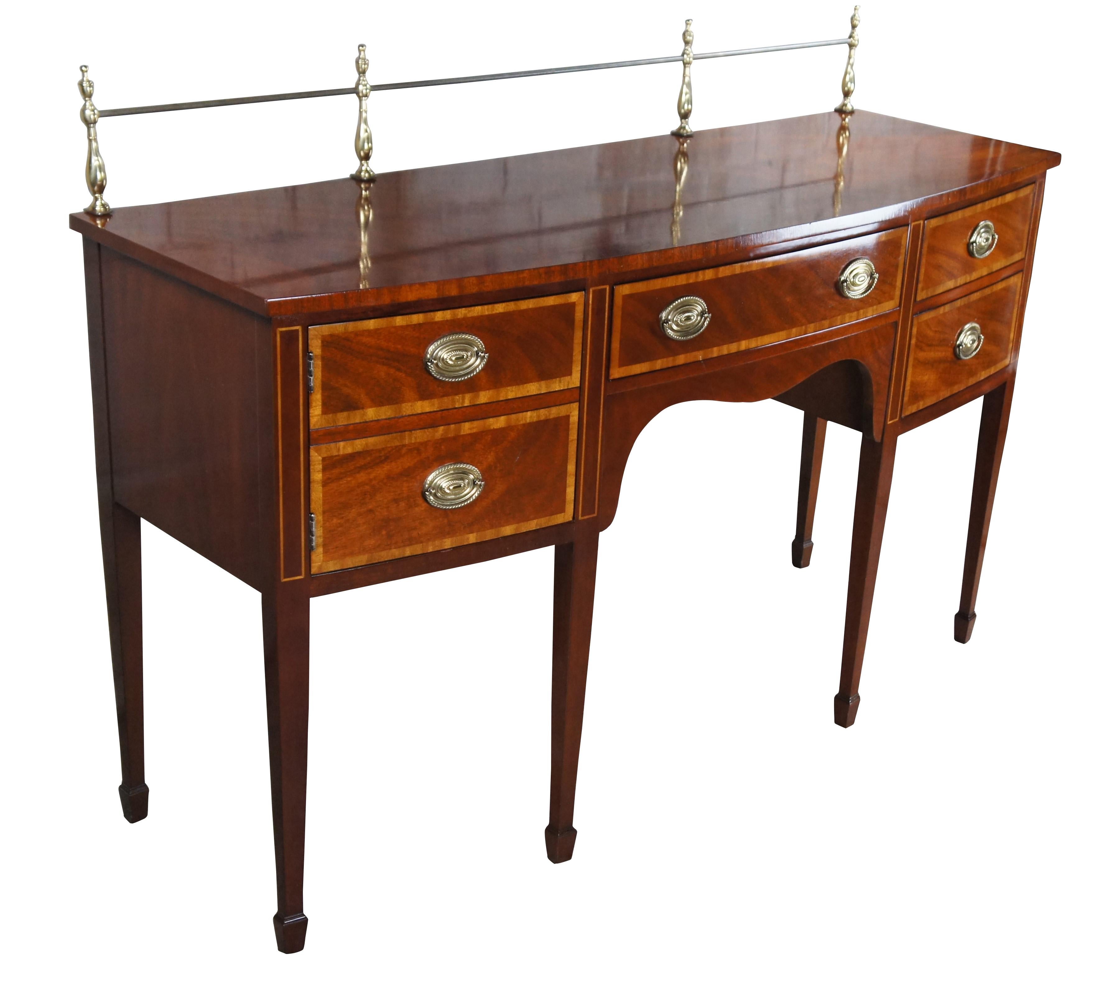 An impressive vintage Kindel Furniture sideboard, circa 1970s. Features a mahogany frame with bowfront, serpentine front, crossbanding, inlay and brass gallery. Includes five dovetailed drawers with oval brass Sheraton / Federal style drawer pulls.
