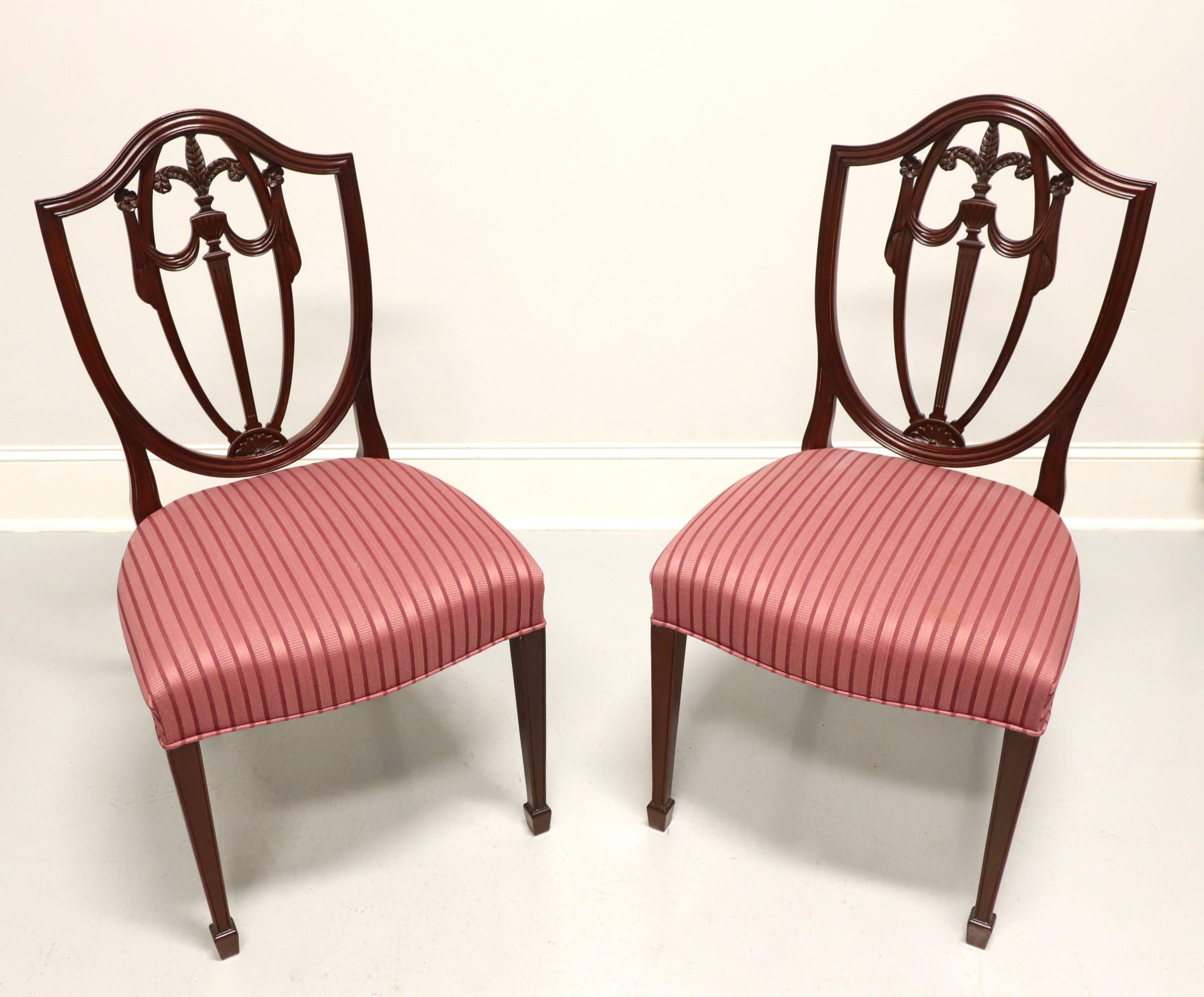A pair of dining side chairs in the Georgian Hepplewhite style by Kindel Furniture. Inlaid mahogany with carved seatbacks with plumes, upholstered seats, and tapered legs with spade feet. Made in Grand Rapids, Michigan, USA, circa 1994. 

Style: