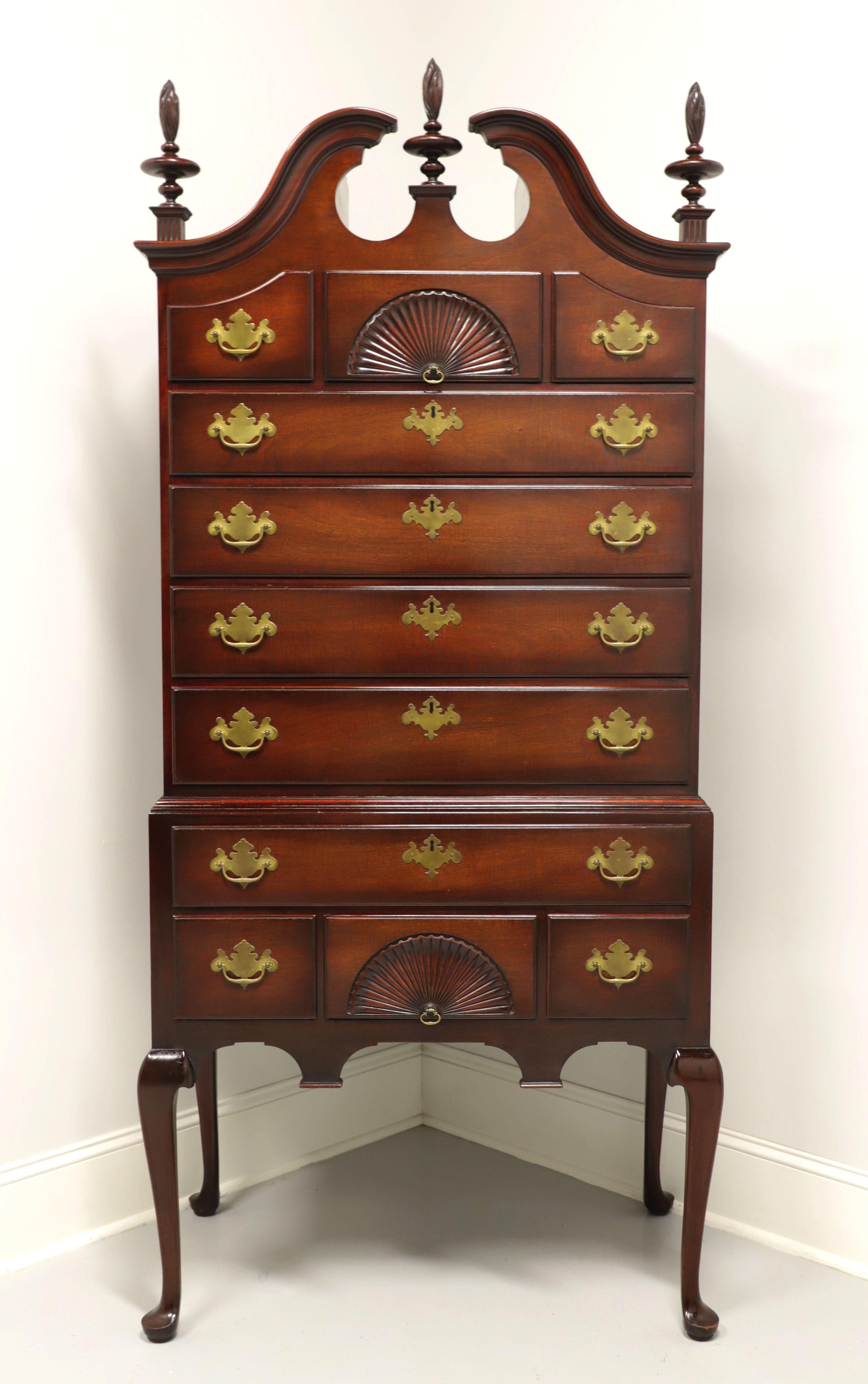 A Queen Anne style highboy chest by Kindel Furniture, of Grand Rapids, Michigan, USA. Solid mahogany with brass hardware; complimented by broken bonnet top, flame form finials, fan carvings, carved apron, and raised on tall cabriole legs with pad