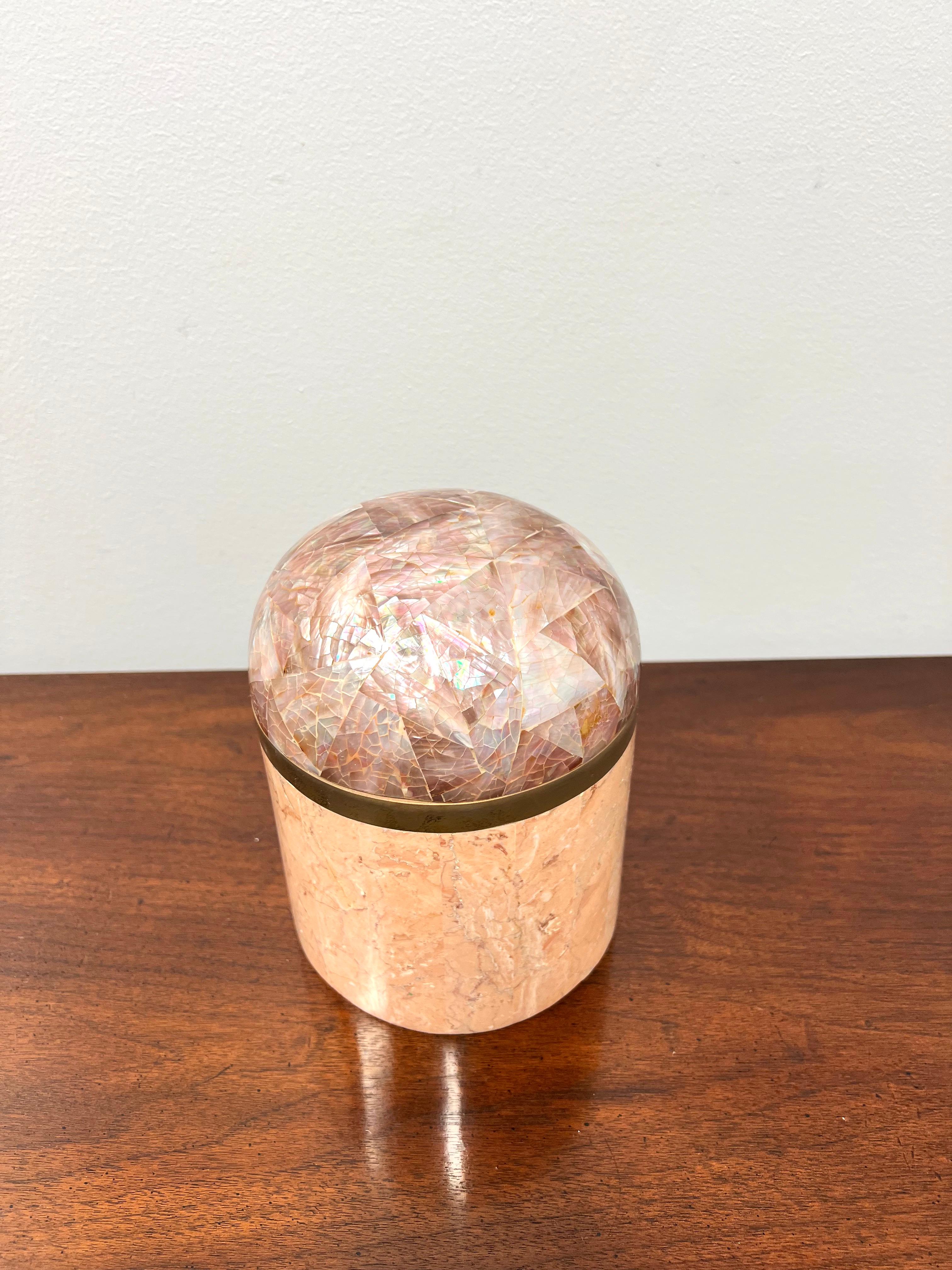 A trinket box with dome lid in tessellated stone by Dara, a division of Kinder-Harris. Box is shades of pink colored tessellated stone tiles in a round shade, removable lid is dome shaped & in shades of amethyst colored patterned tessellated stone