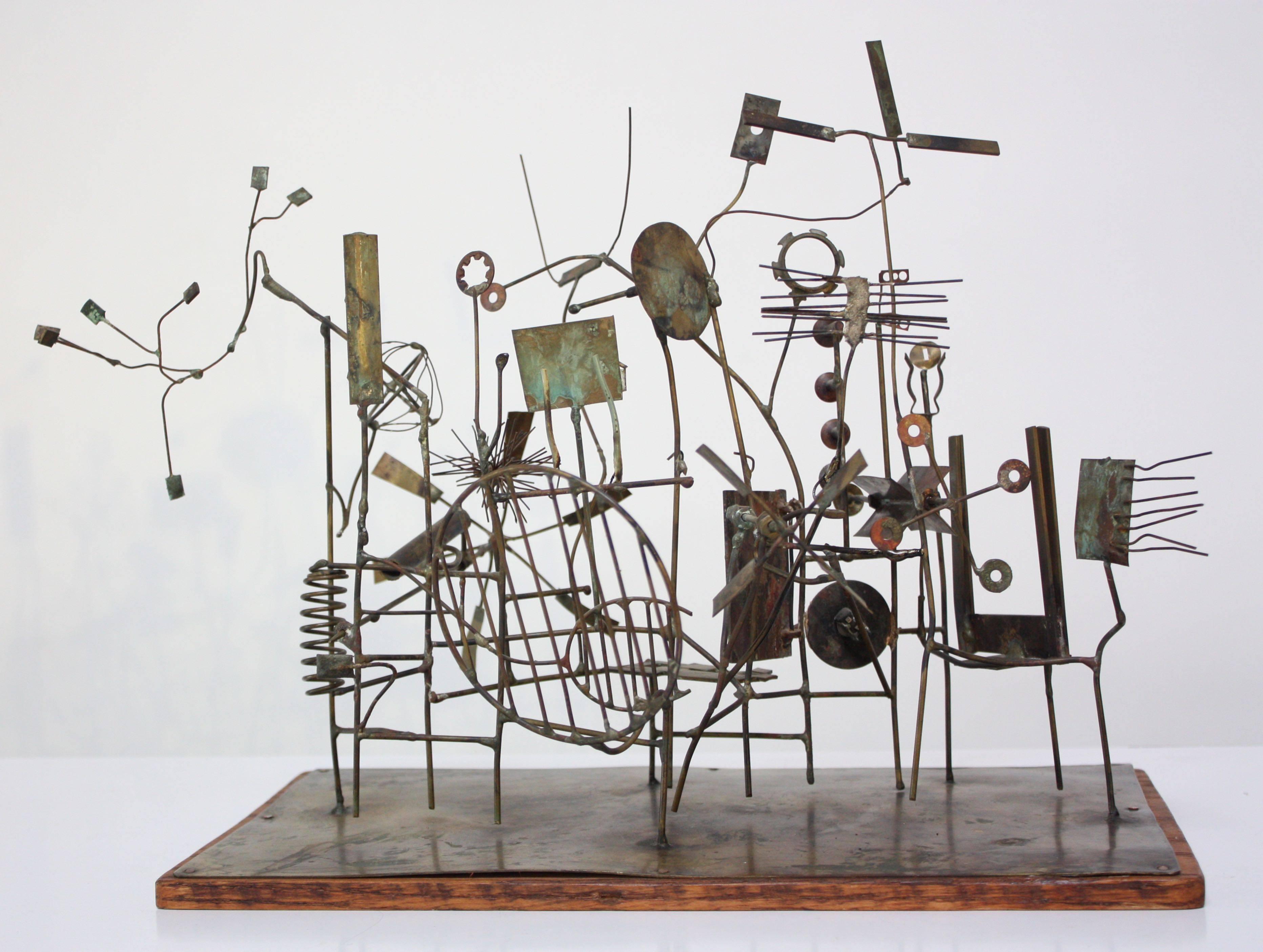 1962 David Hall-Coleman kinetic mixed-metal sculpture entitled, 'Abandoned Carnival Machine.' Extraordinary sculpture composed of torch-cut and soldered brass and copper elements on an oak wood board. Fascinating conversation piece with interactive