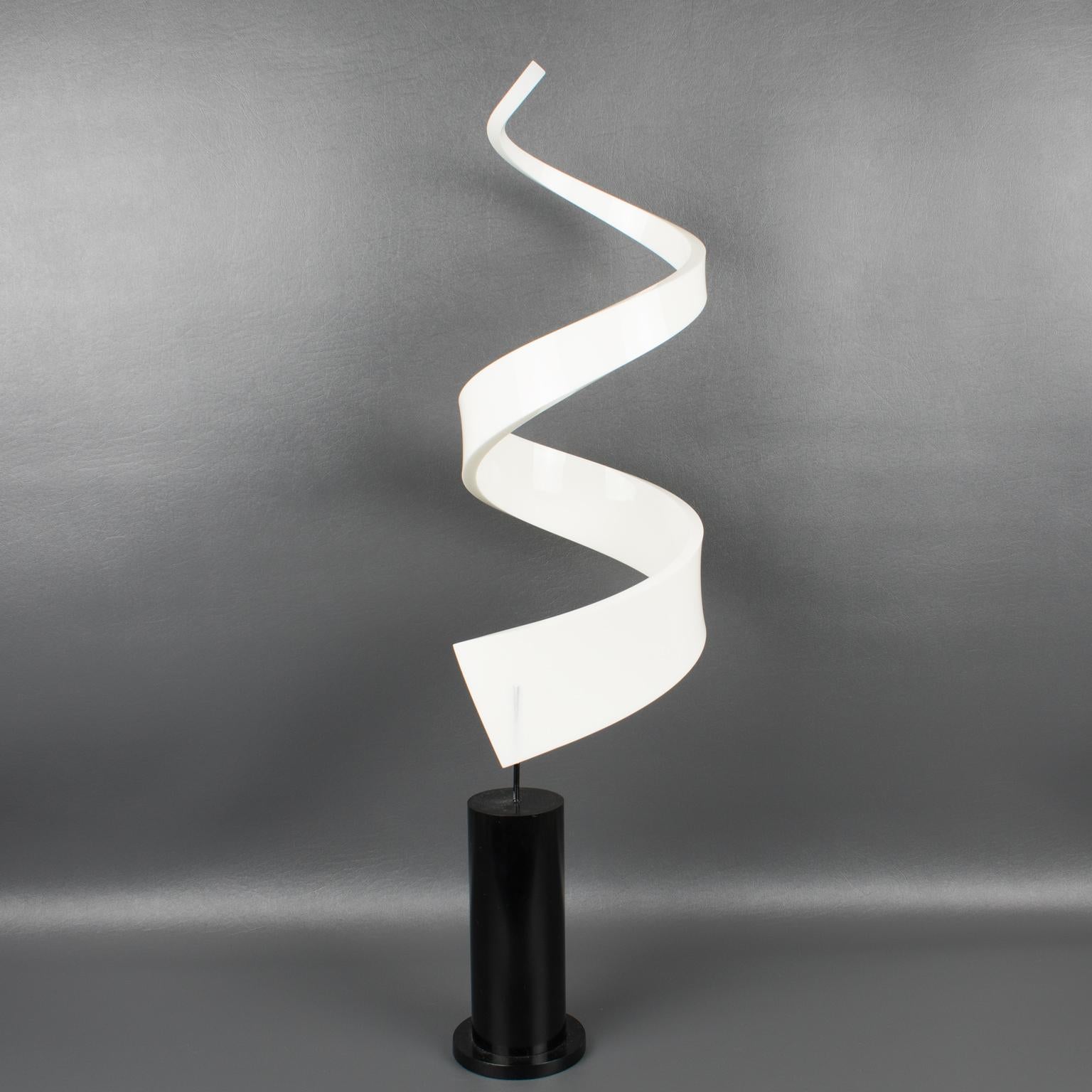 Questa splendida scultura in lucite o plexiglass degli anni '70 vanta una forma geometrica astratta a vortice di colore bianco latte montata su un'alta base a gradini in lucite o acrilico nero. Il pezzo rivela effetti visivi diversi da ogni lato.
