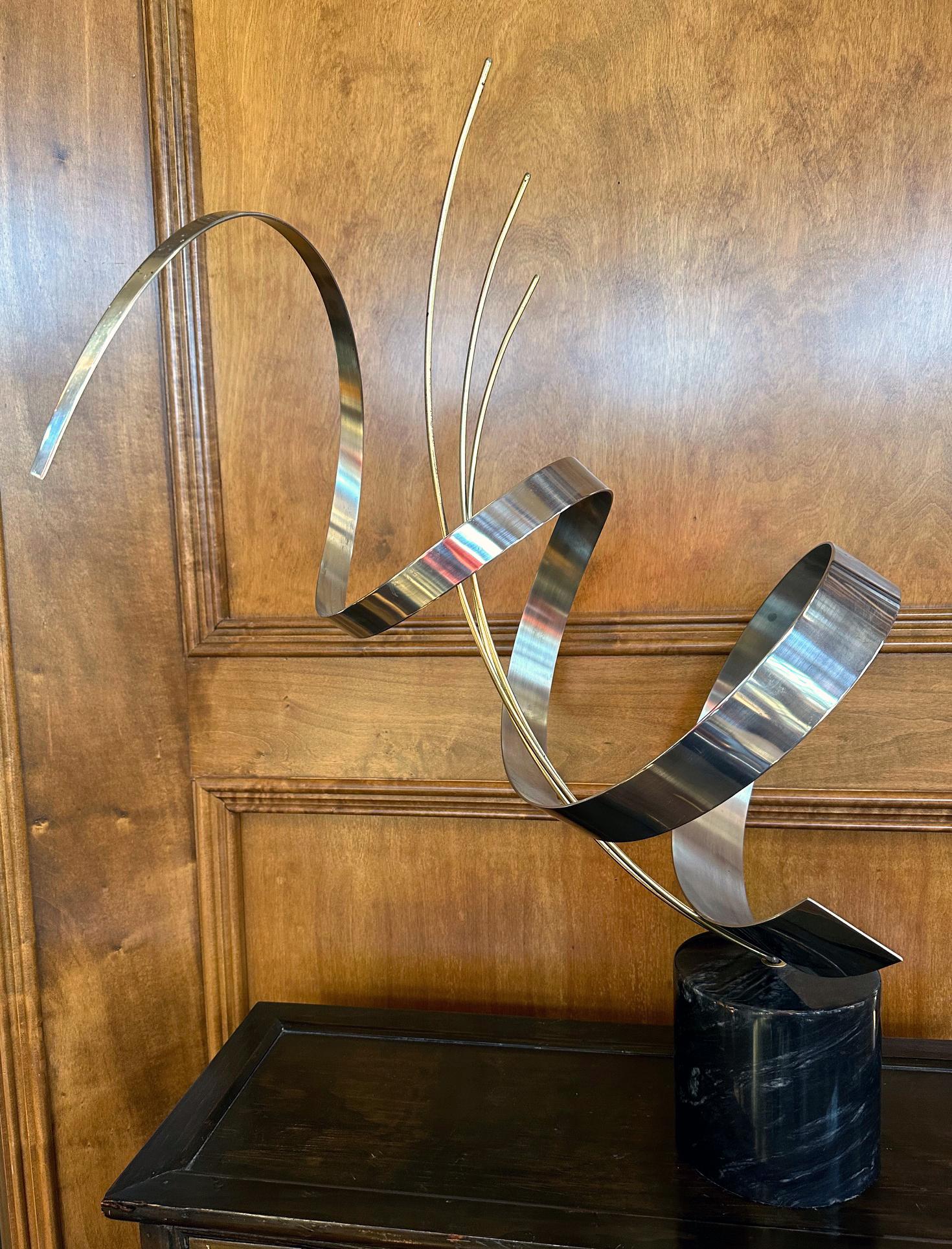 A vintage tabletop sculpture crafted by C. Jere and dated to 1978. The metal sculpture was constructed from chromed steel and brass in an abstract tapering spiral form with curved three brass rods in the center. It is installed on a marble pedestal