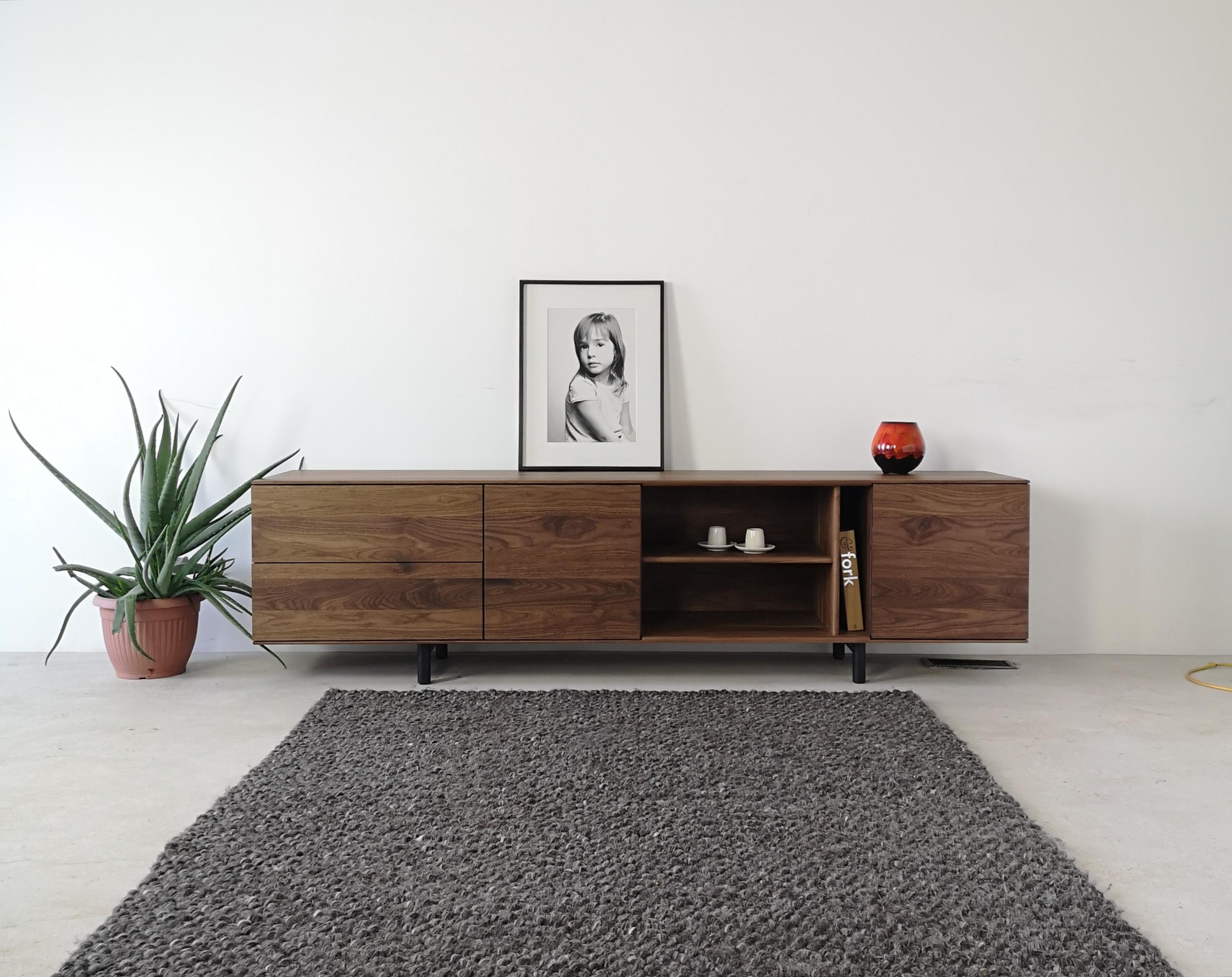 Kinetic von Izm ist ein Sideboard aus massivem Hartholz mit einer asymmetrischen Anordnung von Schubladen, Türen und offenen Regalen mit flächenbündigen, durchgehenden Maserungen. Dieser moderne Schrank kann als Buffet, Kredenz, Audio-/Visualschrank