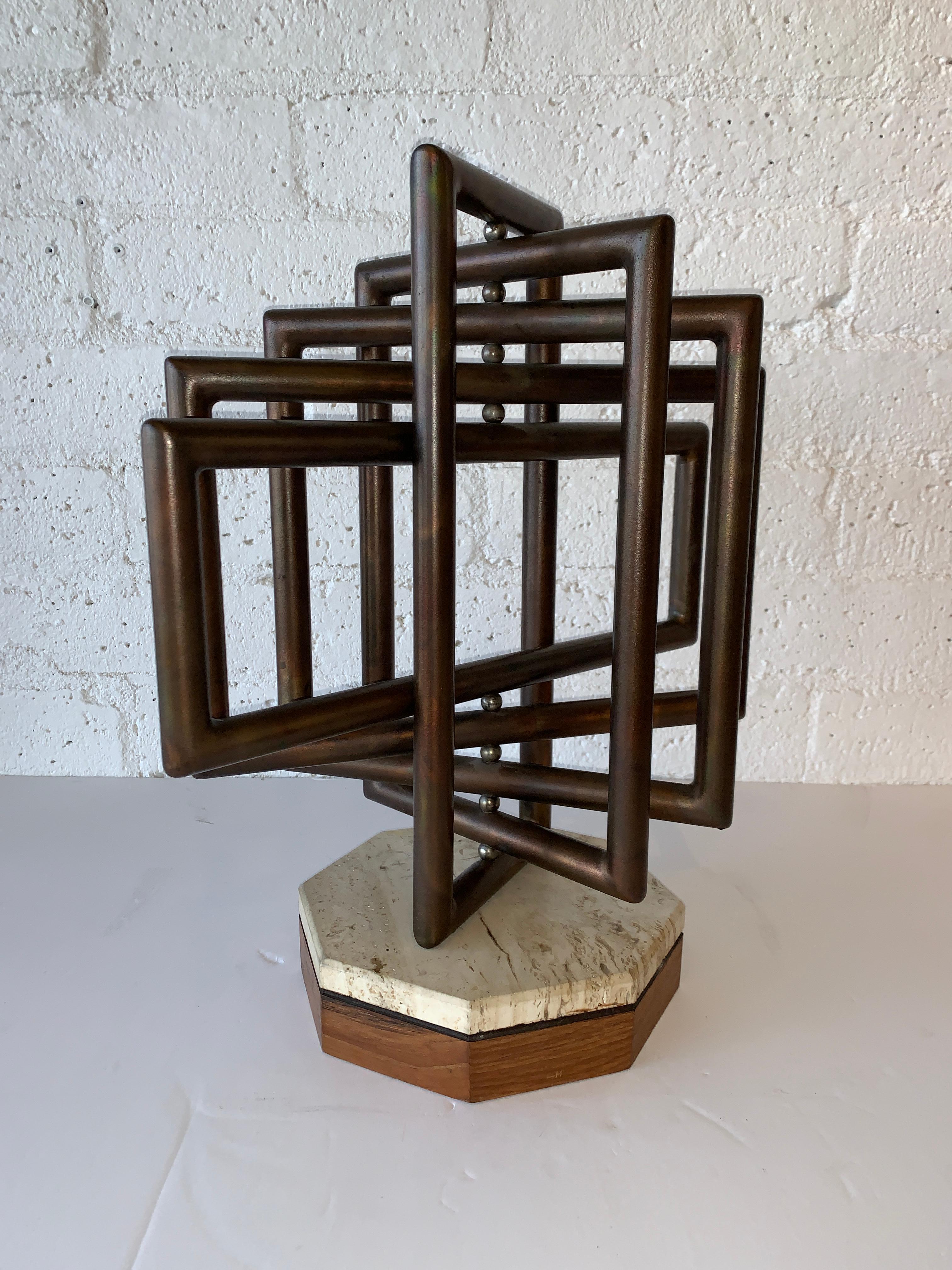 A nice kinetic sculpture by the noted artist Dennis Stewart. Crafted out of copper and steel on a stone and wood base. Great patina. There is a faded label on the base. Overall good age appropriate condition with wear and tarnish to copper and marks