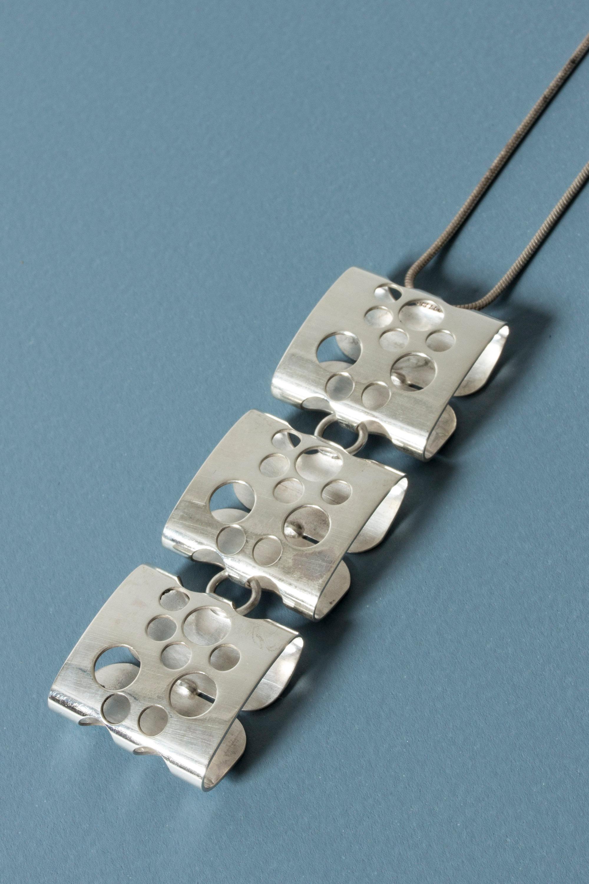 Very cool kinetic silver pendant by Elis Kauppi, made up from three sections. Each section is a cushion design, perforated with holes. Playful and elegant. Also looks good worn on a neckring.