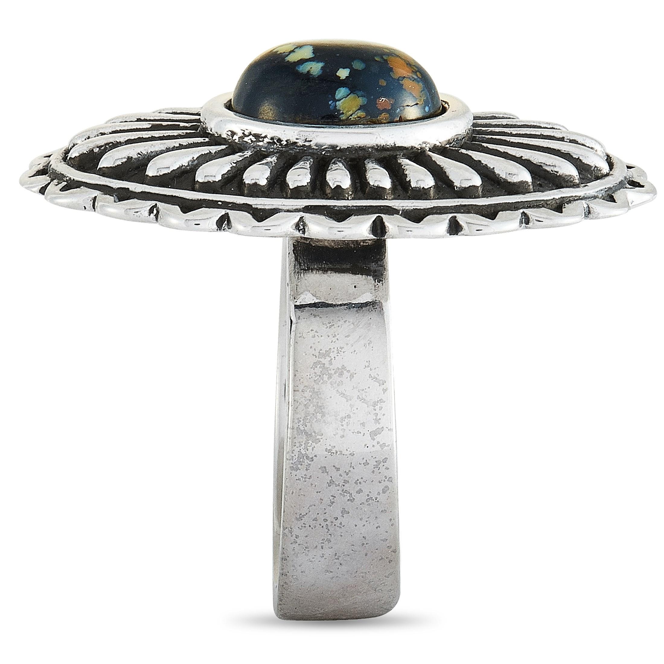The King Baby “Large Starburst Concho” ring is crafted from silver and set with an 8 by 10 mm spotted turquoise. The ring weighs 17 grams and boasts a band thickness of 6 mm and a top height of 8 mm, while top dimensions measure 21 by 31 mm.

This