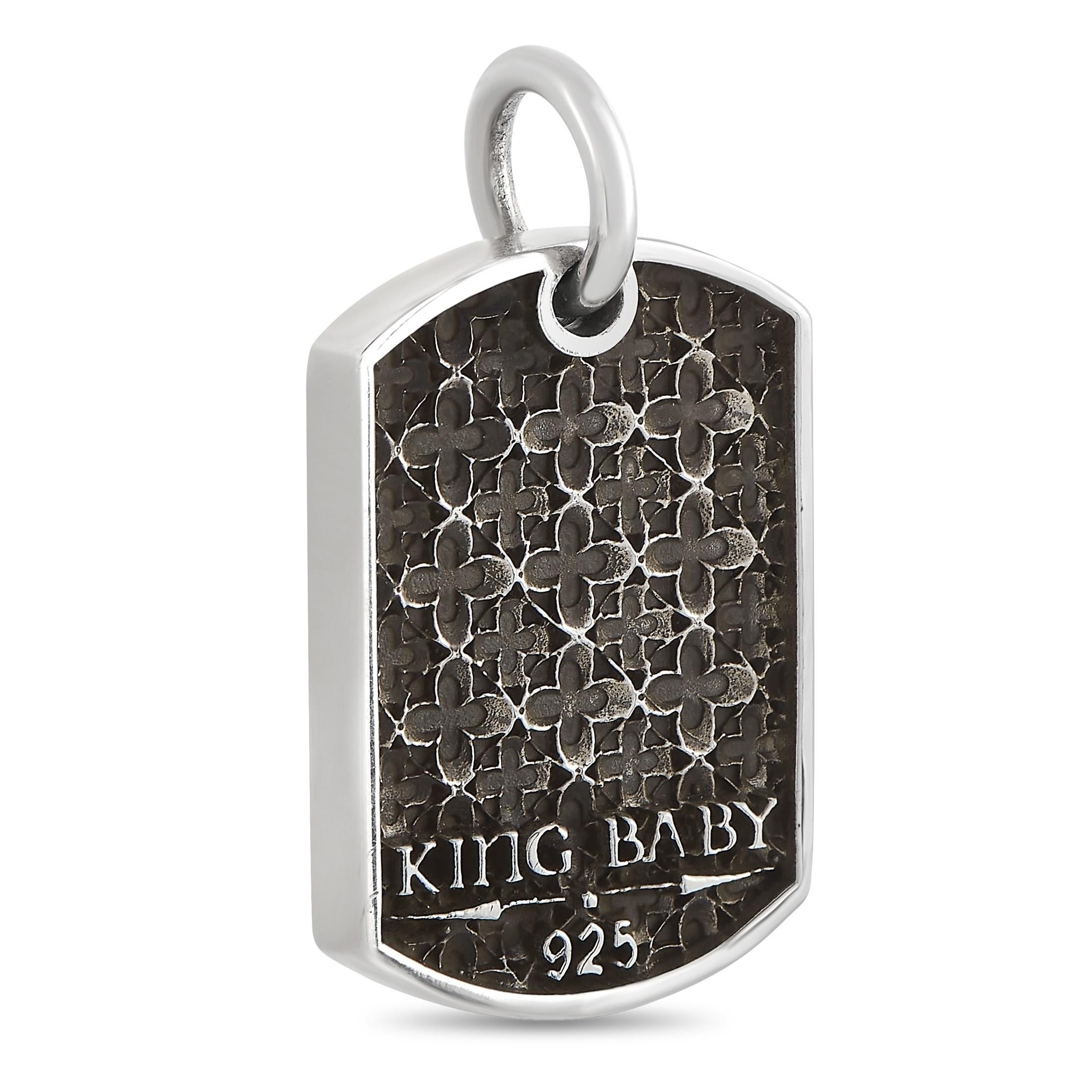 This King Baby dog tag pendant is made of silver and embellished with black diamonds. The pendant measures 1.5” in length and 1” in width.

Offered in brand-new condition, this item includes the manufacturer’s box.