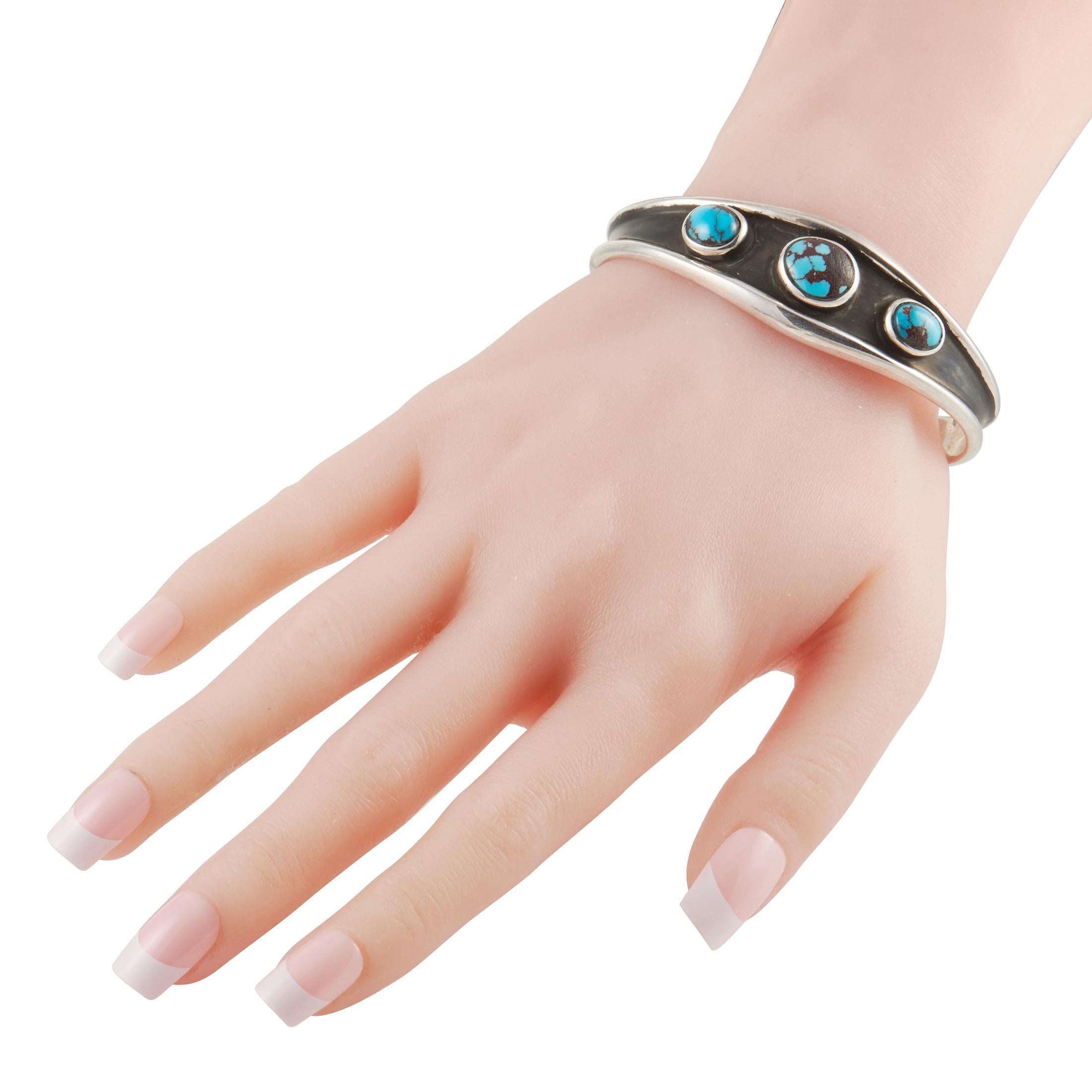 Captivating colors and a vintage-inspired sense of style make this cuff bracelet from King Baby a must-have for anyone with a rugged, natural aesthetic. At the center of this bangle’s darkened Sterling Silver setting are a trio of turquoise stones.