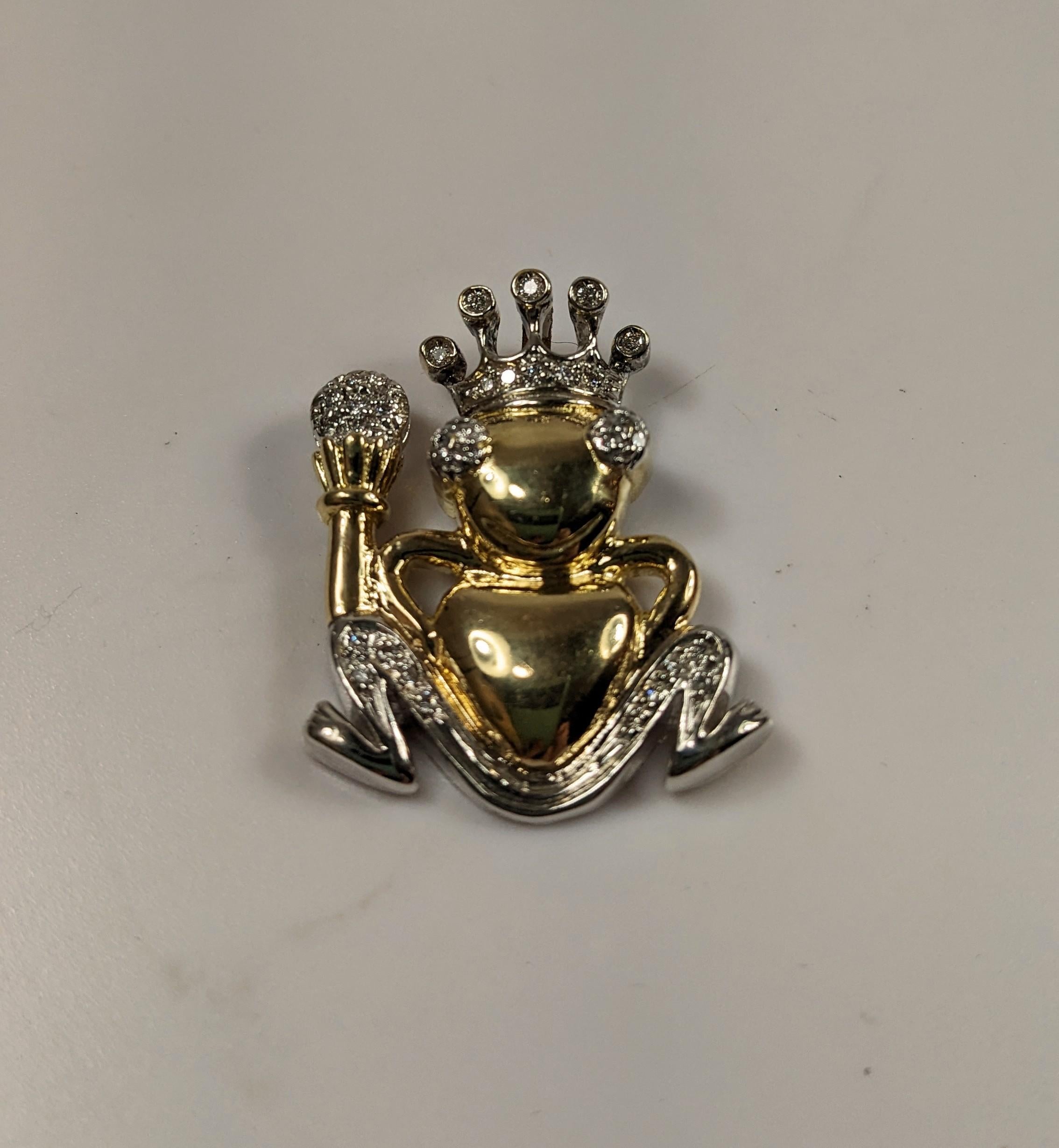 18k yellow gold pendant with frog motif with scepter and crown decorated with brilliant whites in white gold views
34 bts  0,30 ct aprox
Color H  Purity VS
Measure  28mm  1,1 inches
Weight  8,1 gr

PRADERA is a  second generation of a family run