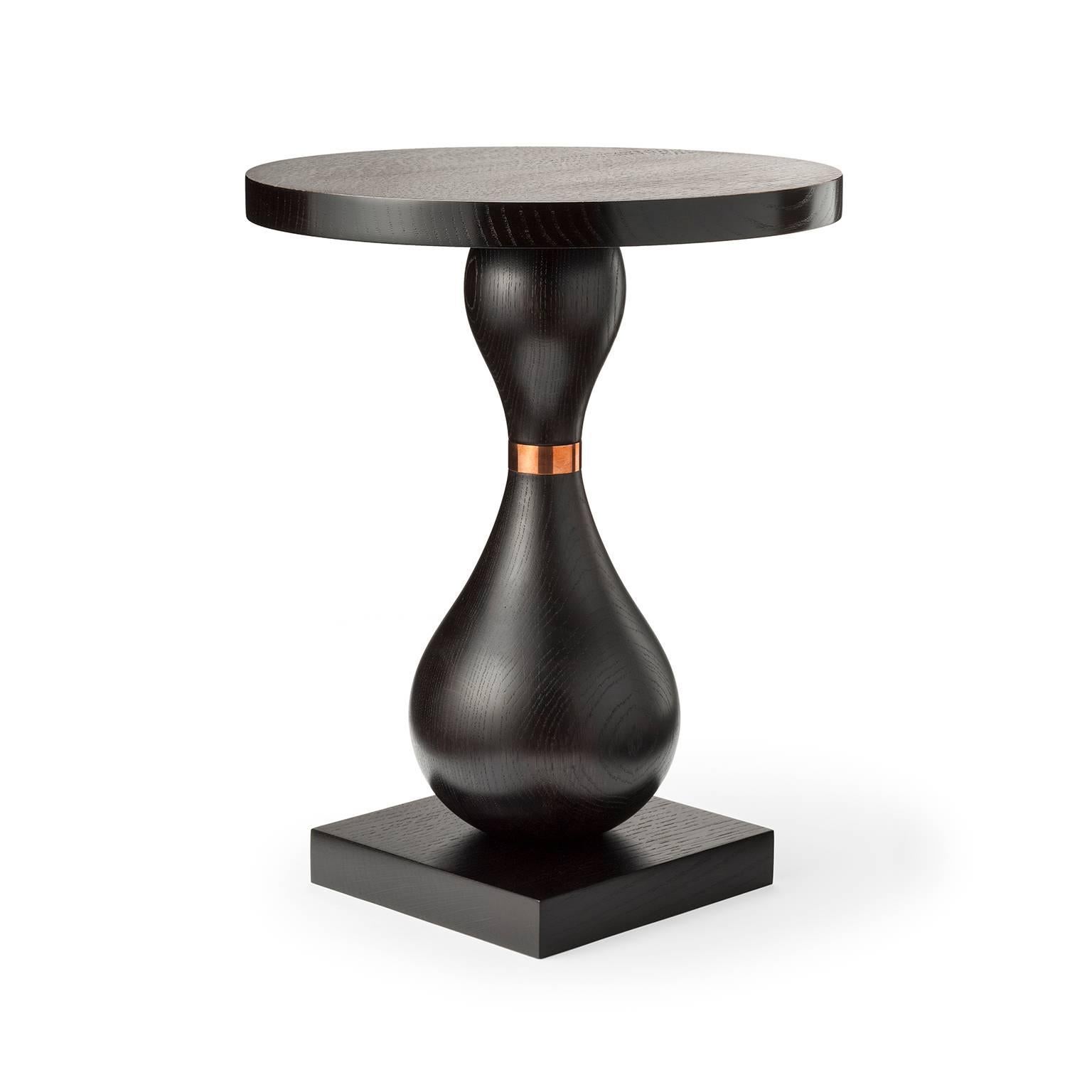 Possessing a beautifully curvaceous shape accentuated by the use of a dark ebonized finish and punctuated by its copper detail, this unique occasional table would complement any of our upholstered pieces. The King Pin occasional table is shown here