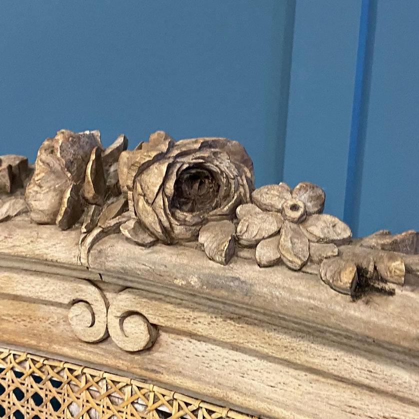 King size 5’ wide. Incredible caned bed that is awaiting full restoration. The frame is in very good condition but will need to be stained and polished. The bed has wonderful decorative flowers carved on both ends and the side rails also have cane