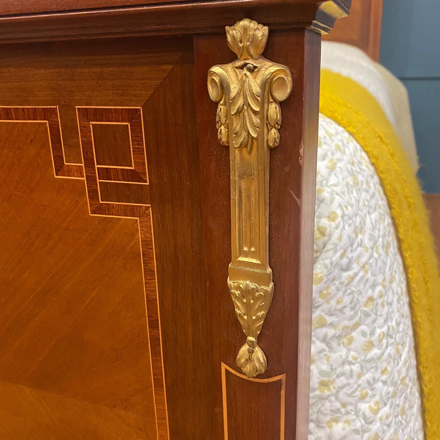 Lovely Walnut bed displaying laurel swag decorative inlaid marquetry, inlaid fruit wood frame, ormolu gilded decorative highlights on the headboard and foot end edges and finished with brass feet detailing. The bed has been sympathetically restored.