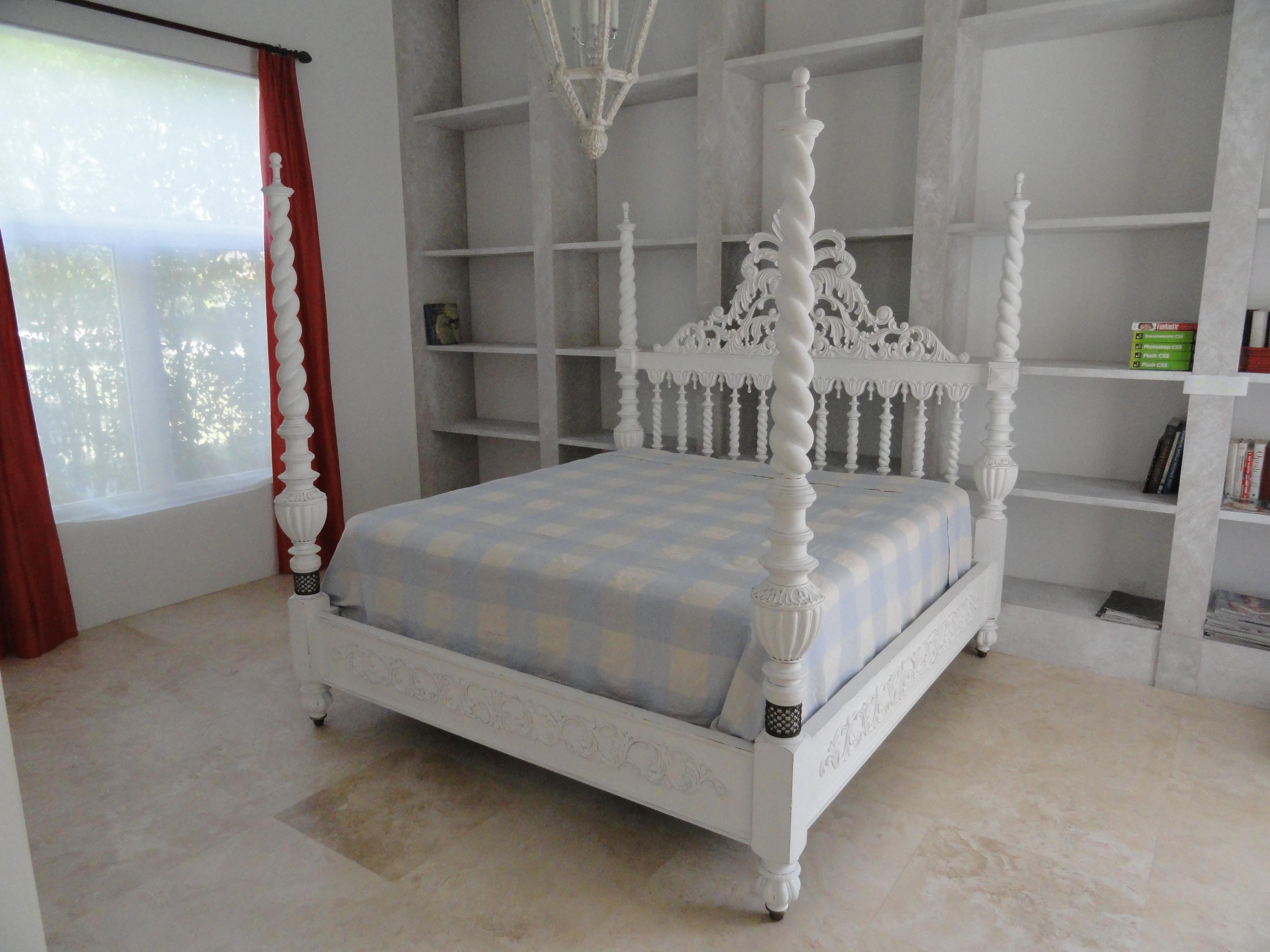 King size plantation style four-poster bed. Head board features twist columns with an elegant carved cartouche. Four posters are carved wood in a twist pattern. Beautiful detail on base of bed. Custom white painted finish. Bed frame only. Does not